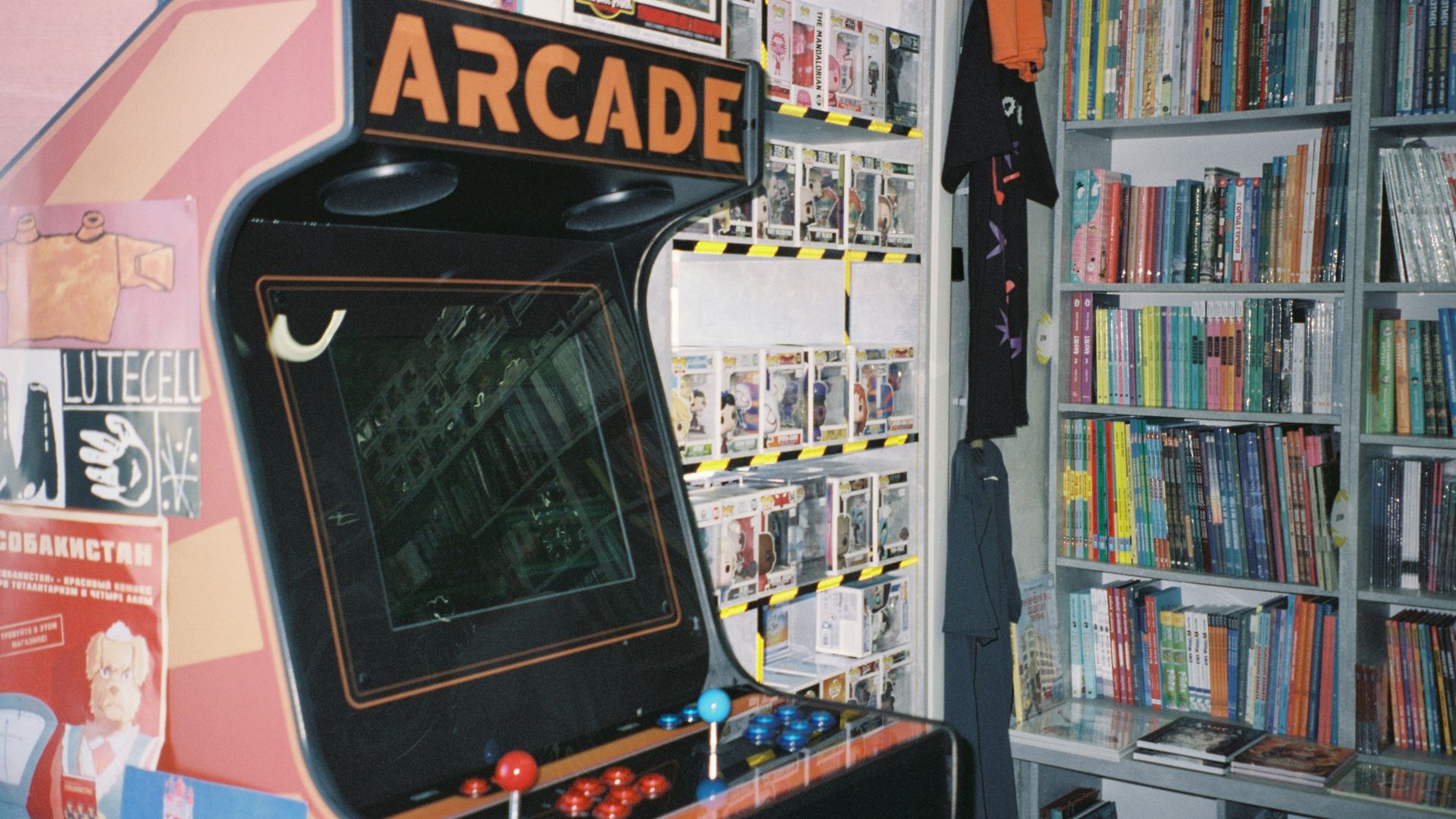 An arcade machine in front of a bookshelf