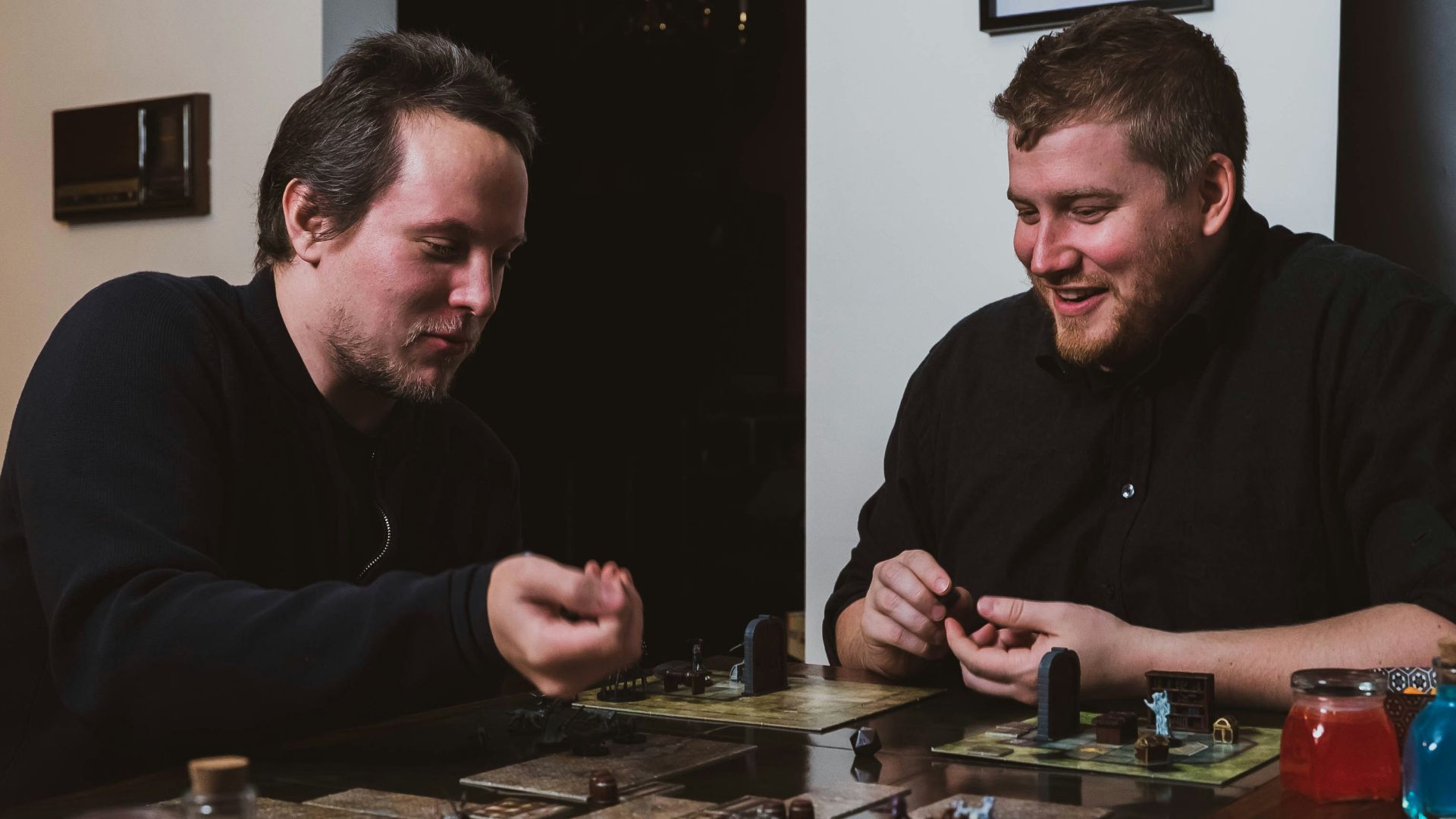 two men sitting at a table playing a board game
