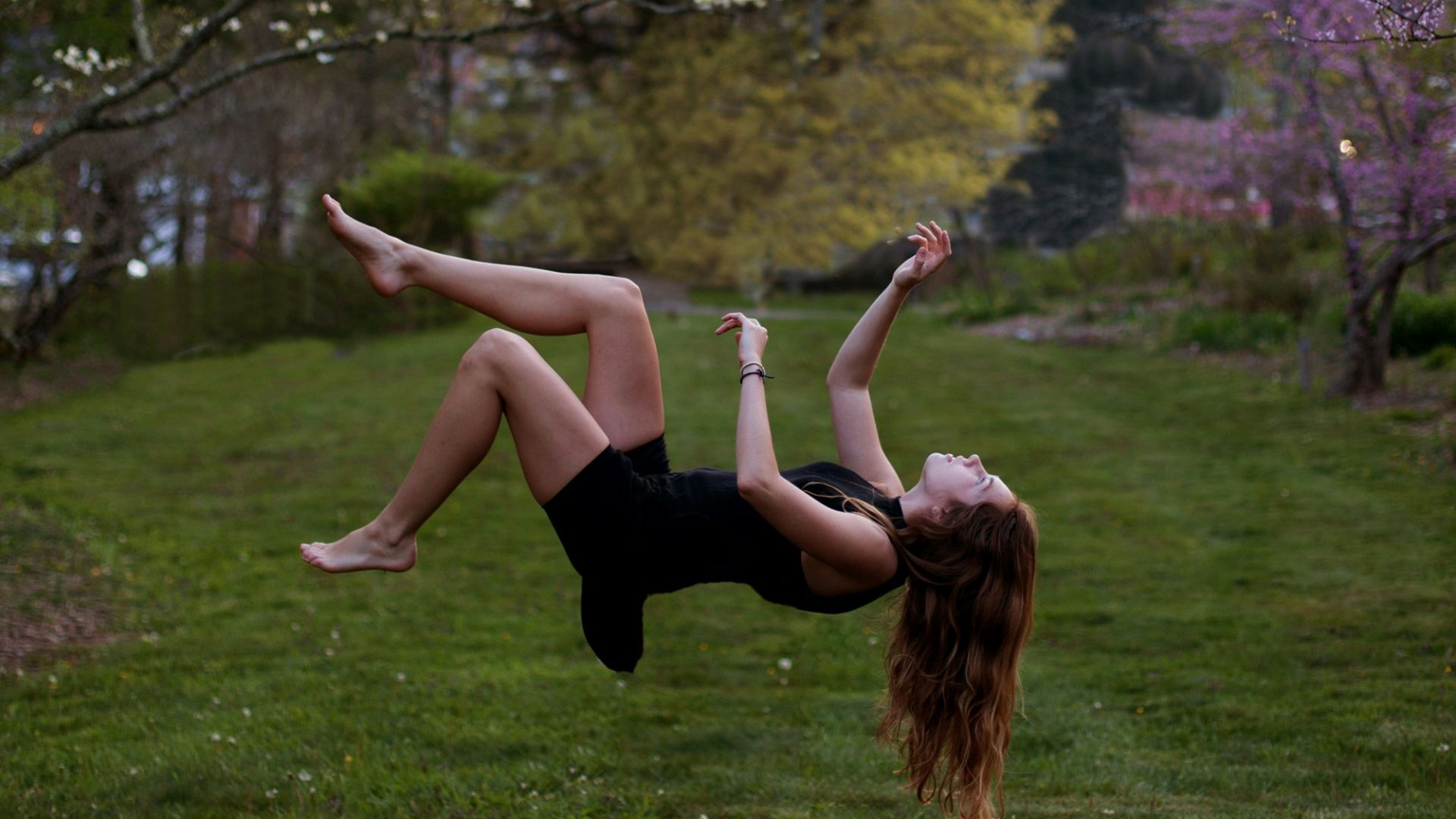 woman back flipping in the garden
