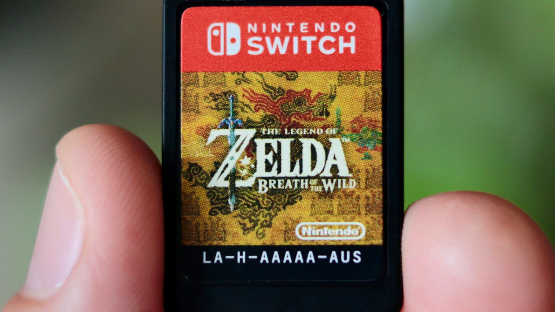a hand holding a nintendo wii game card