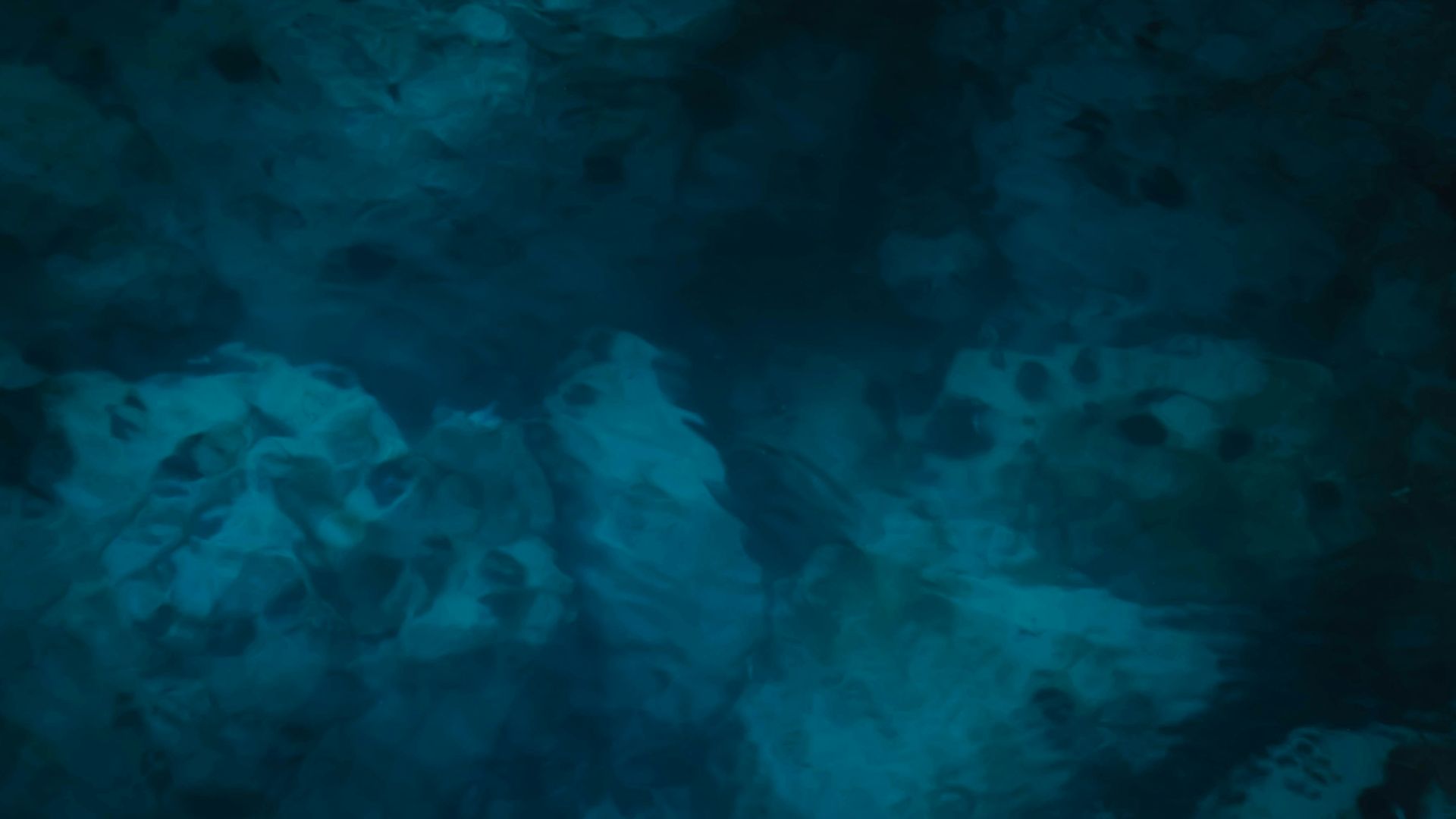 A dark room with a blue light coming from the ceiling