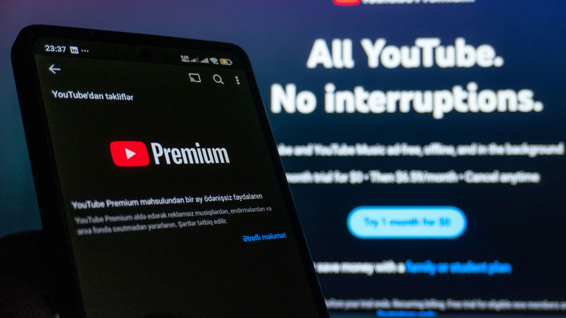 Smartphone displaying youtube premium next to TV screen.