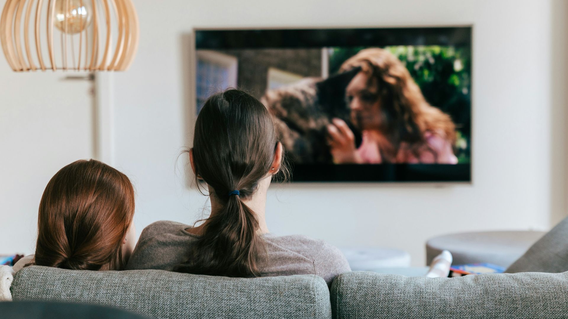 a couple of women sitting on top of a couch