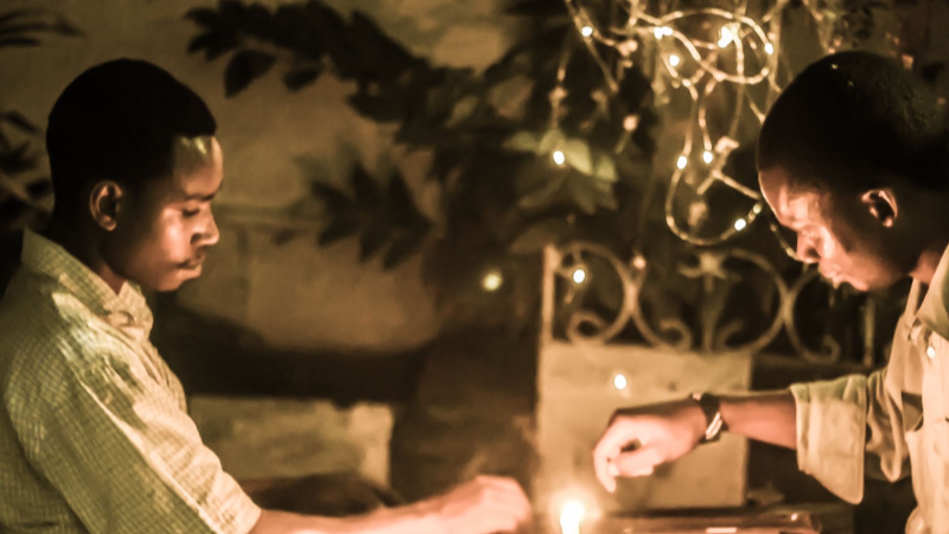 File:Playing africa's well known drafts game within a candle light in tanzania.jpg