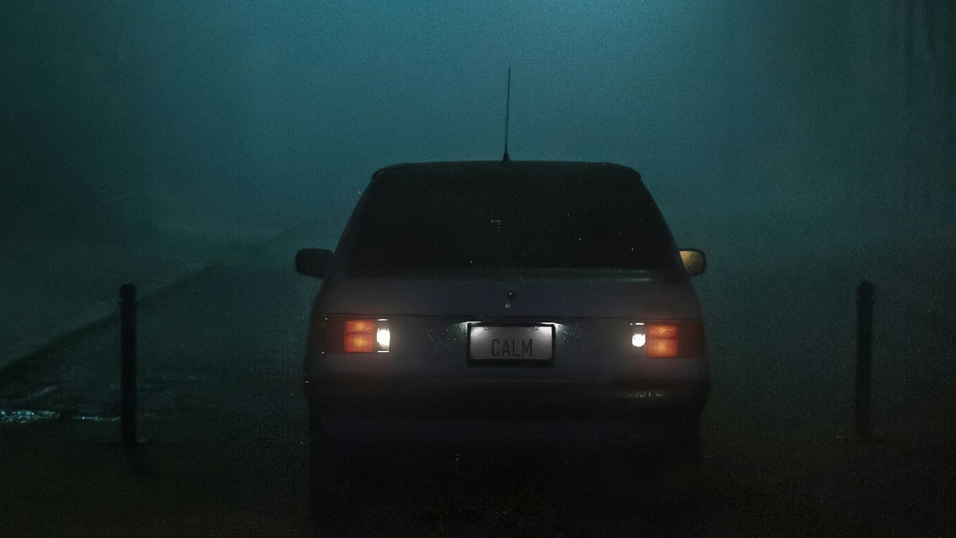 a car parked in a foggy parking lot at night