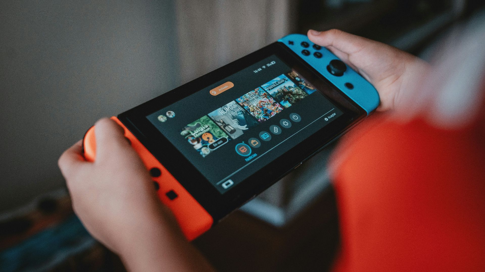 person holding black and orange nintendo switch