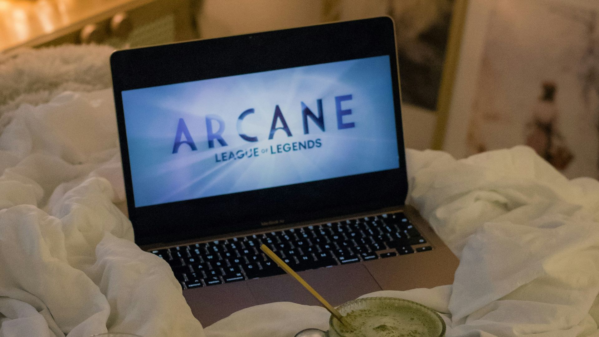 An open laptop computer sitting on top of a bed