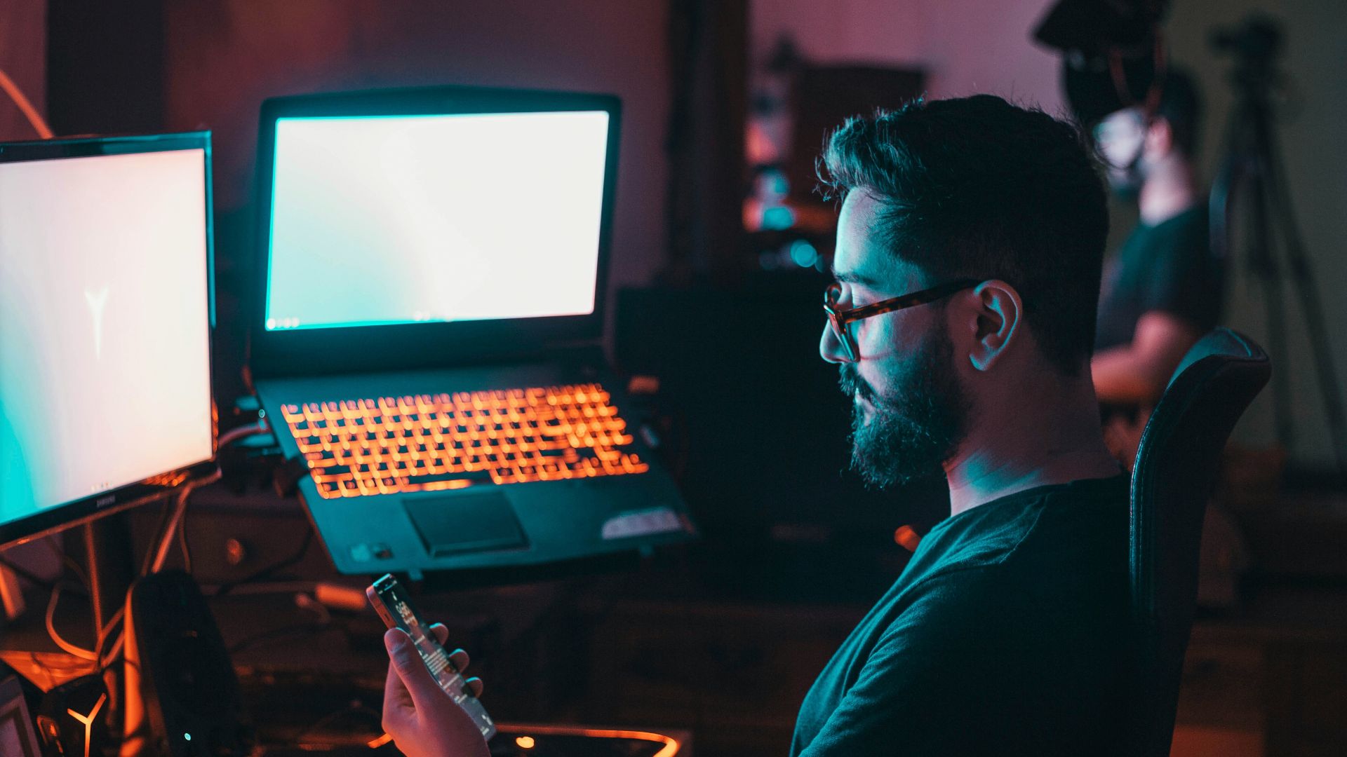 man in blue shirt wearing black framed eyeglasses using black laptop computer