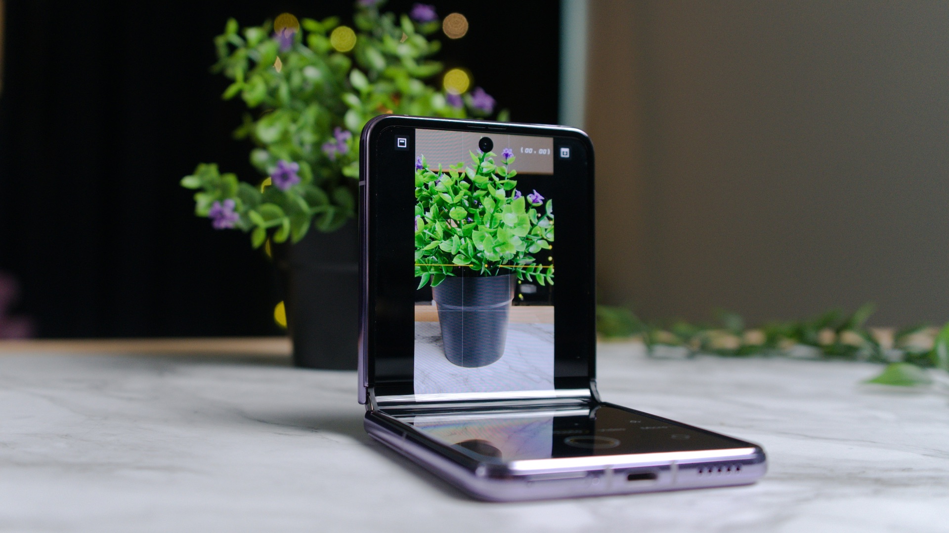 a cell phone sitting on top of a table next to a potted plant