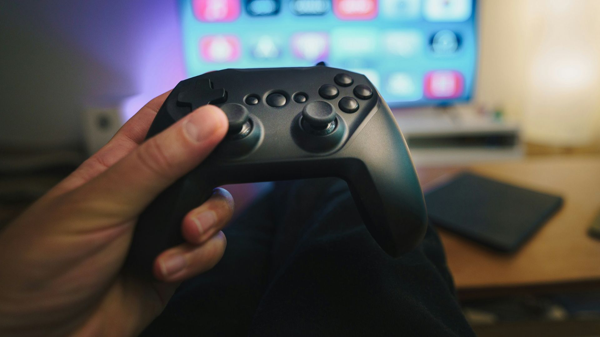 A person holding a video game controller in front of a computer