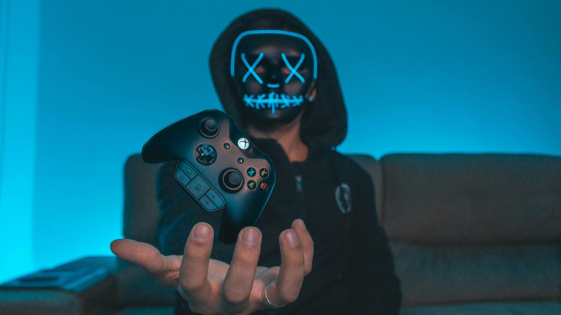 person sitting on chair while holding Xbox One controller
