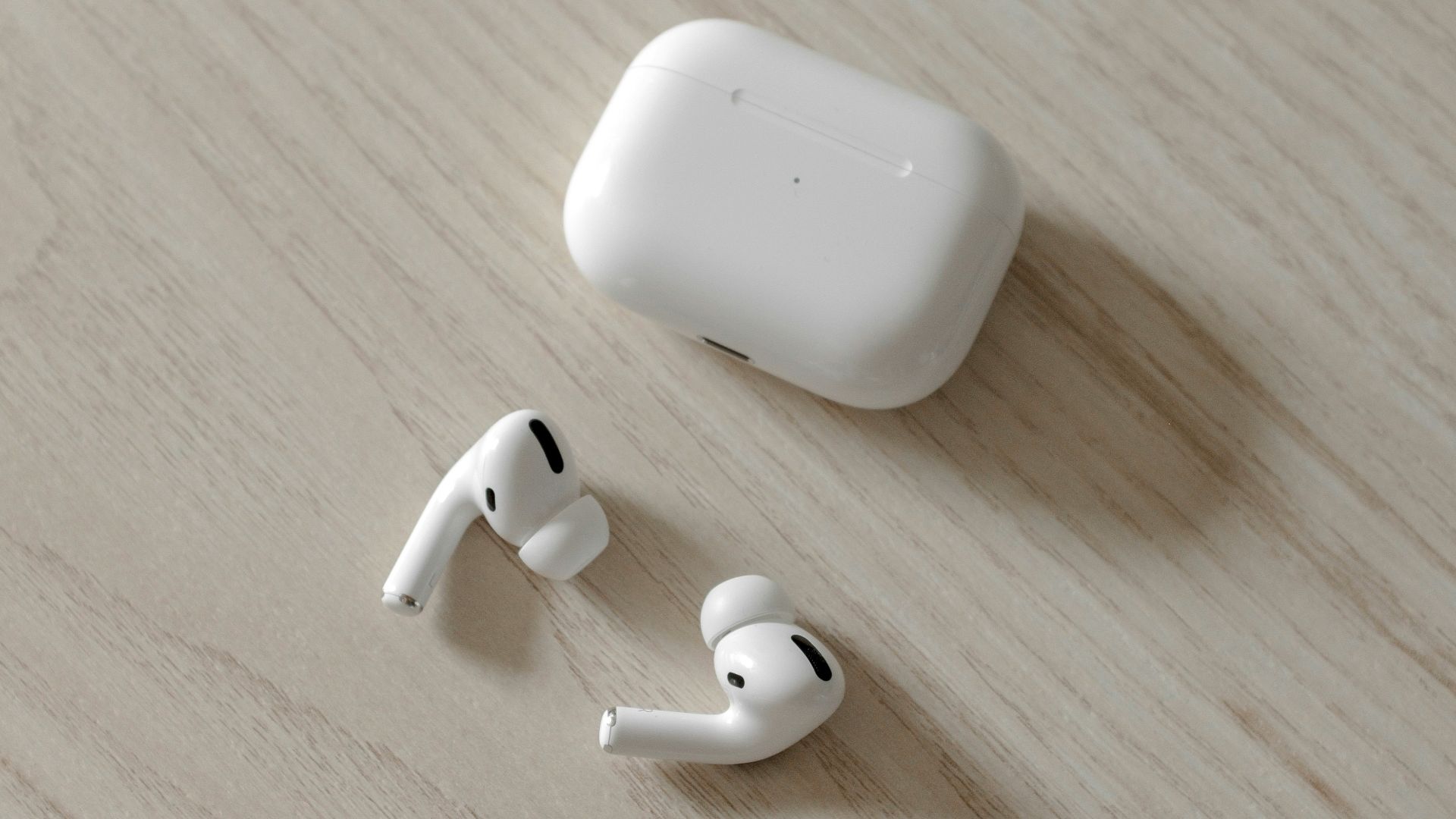 white apple airpods on brown wooden table