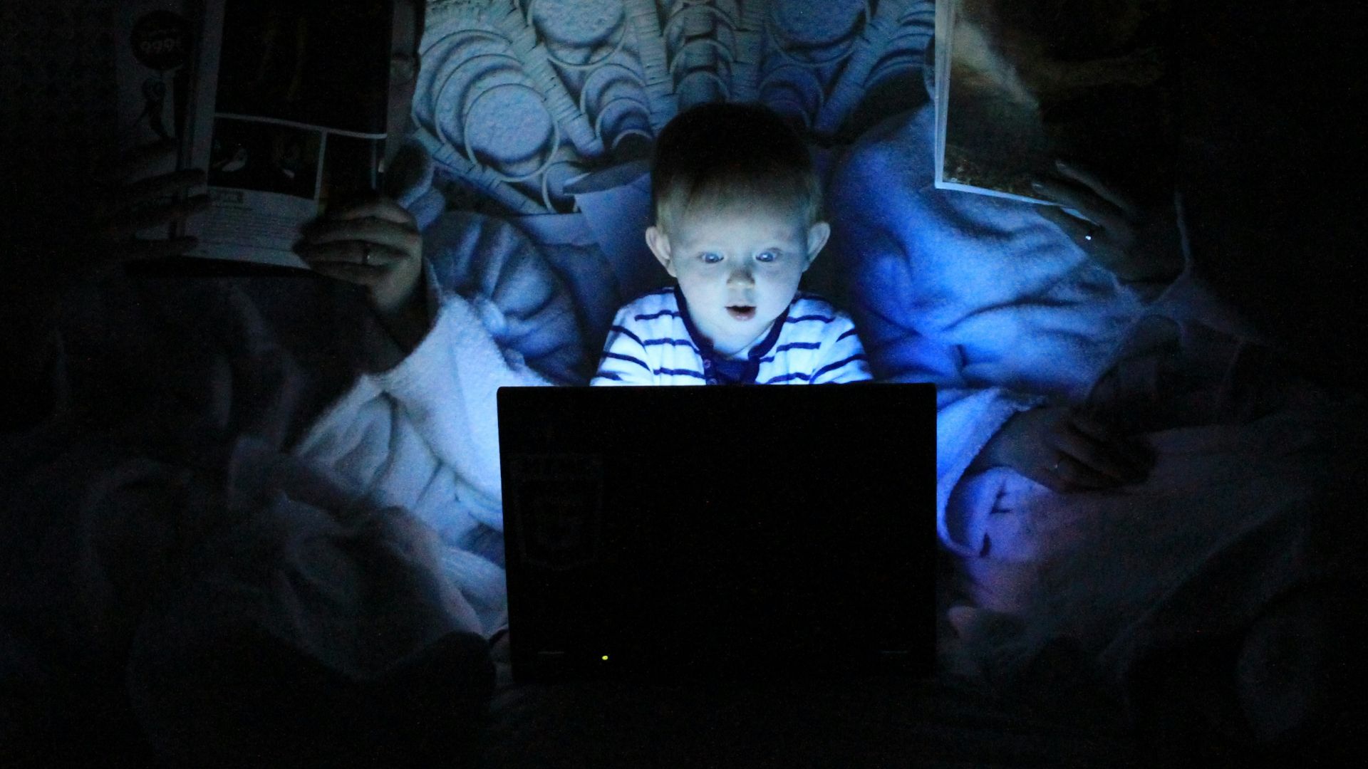 boy playing at laptop inside room