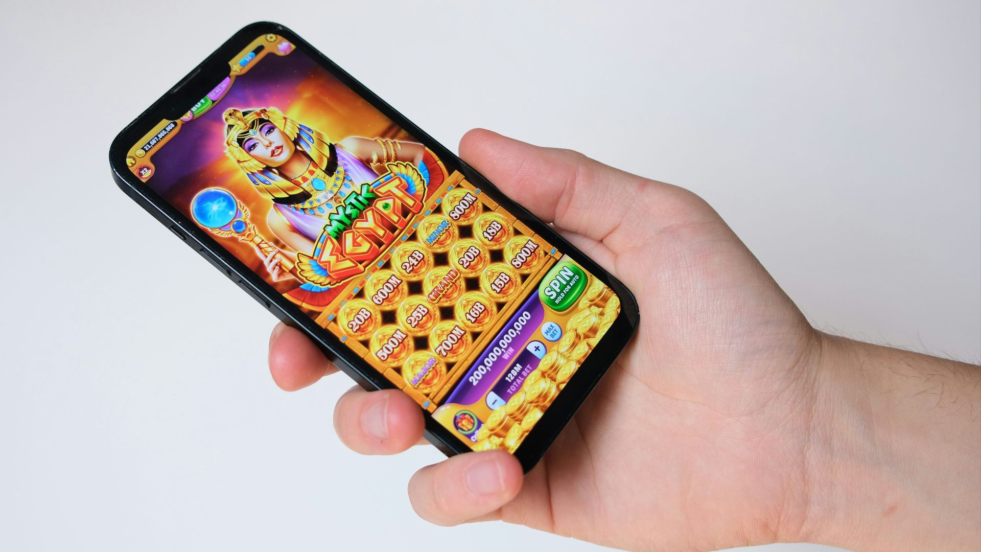 A hand holds a phone with an egyptian-themed game.