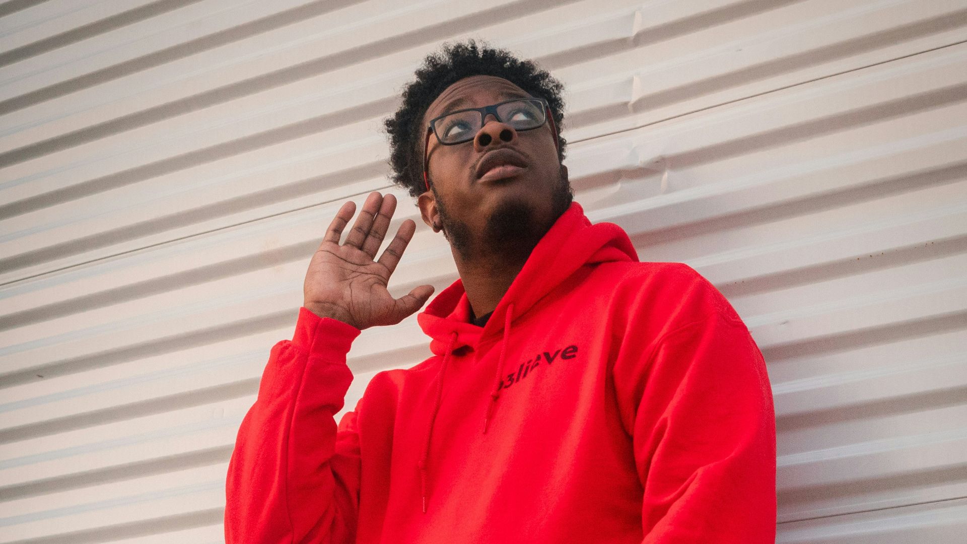 man in red dress shirt and blue denim jeans