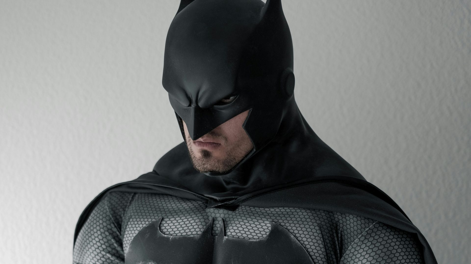 man in black and gray stripe hoodie sitting on brown wooden chair