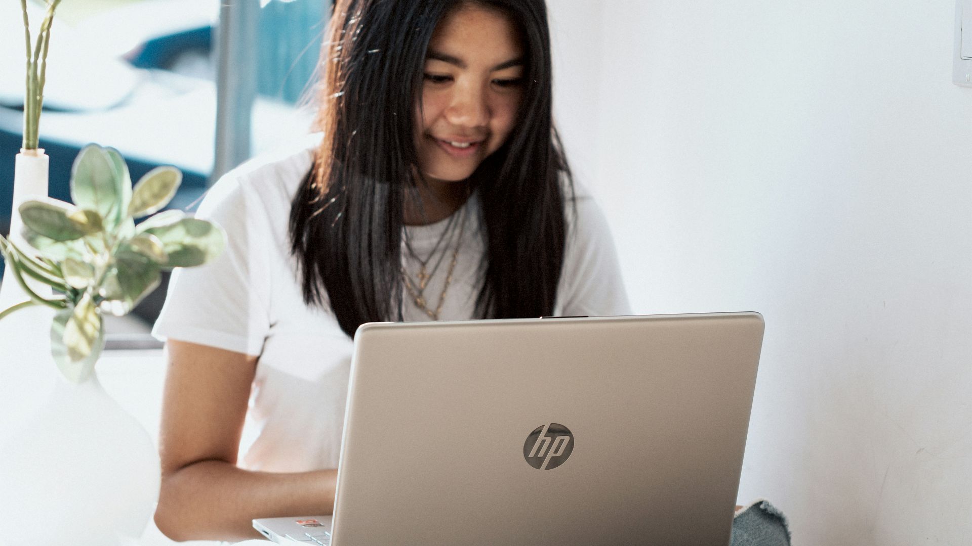 woman in white shirt using laptop