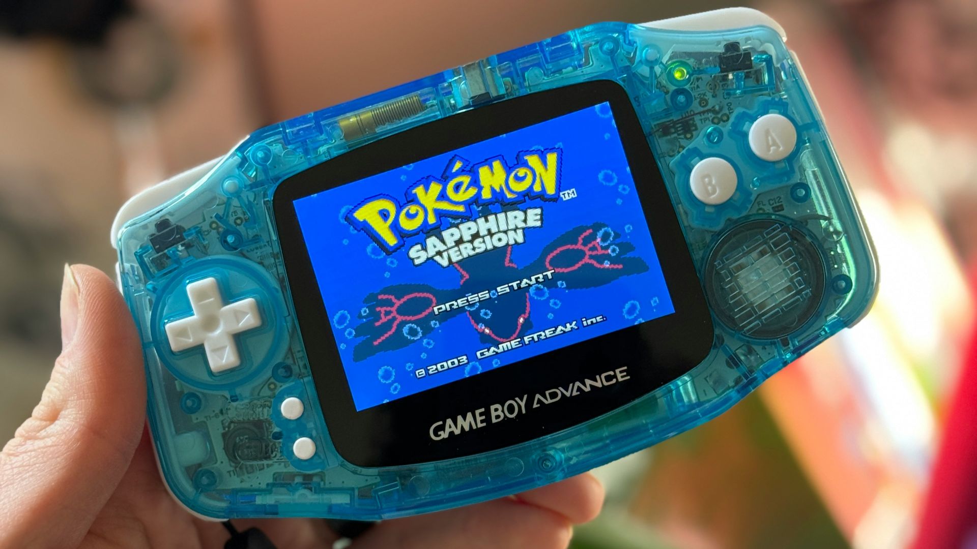 a person holding a gameboy in their hand