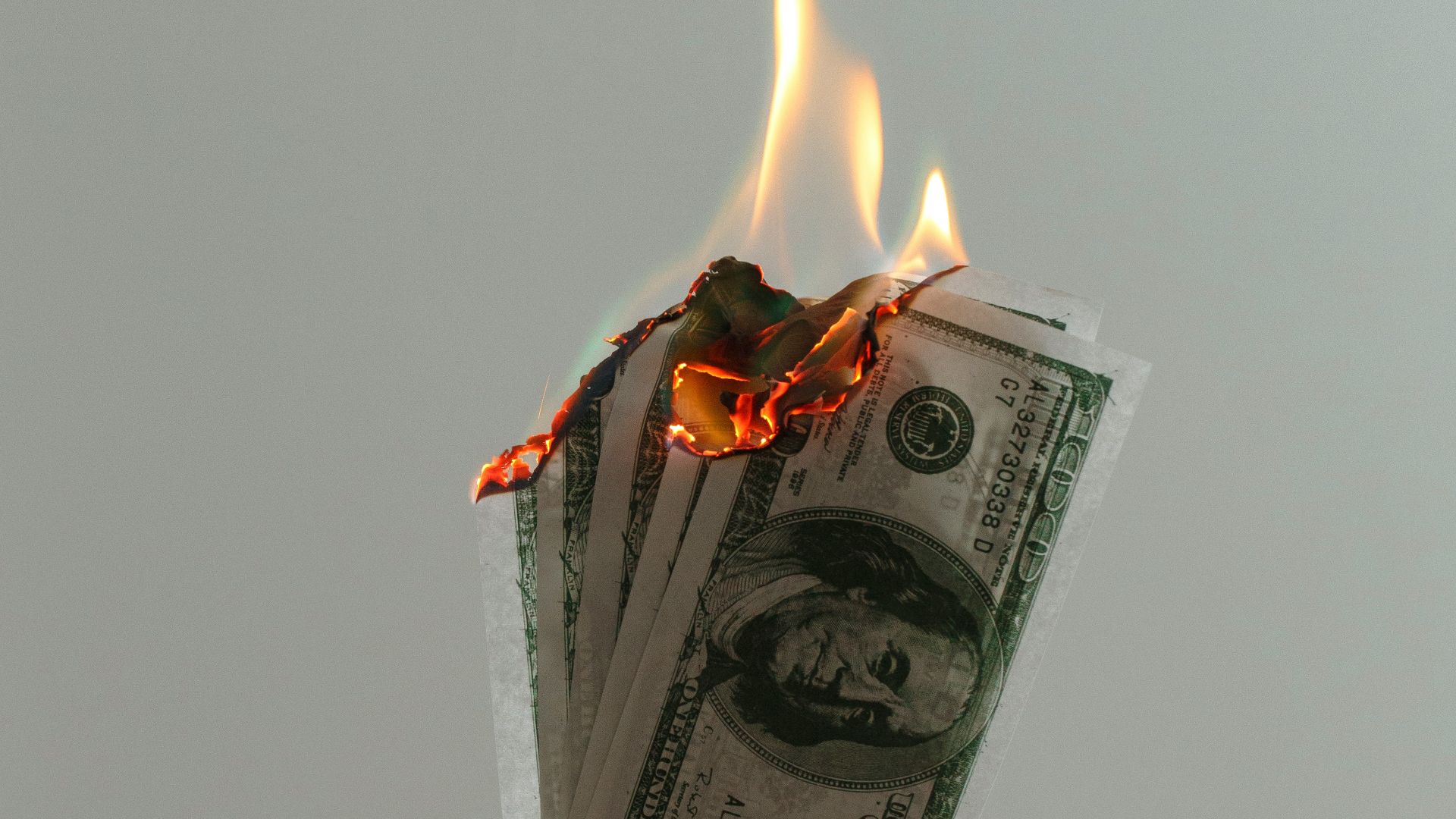 time lapse photography of several burning US dollar banknotes