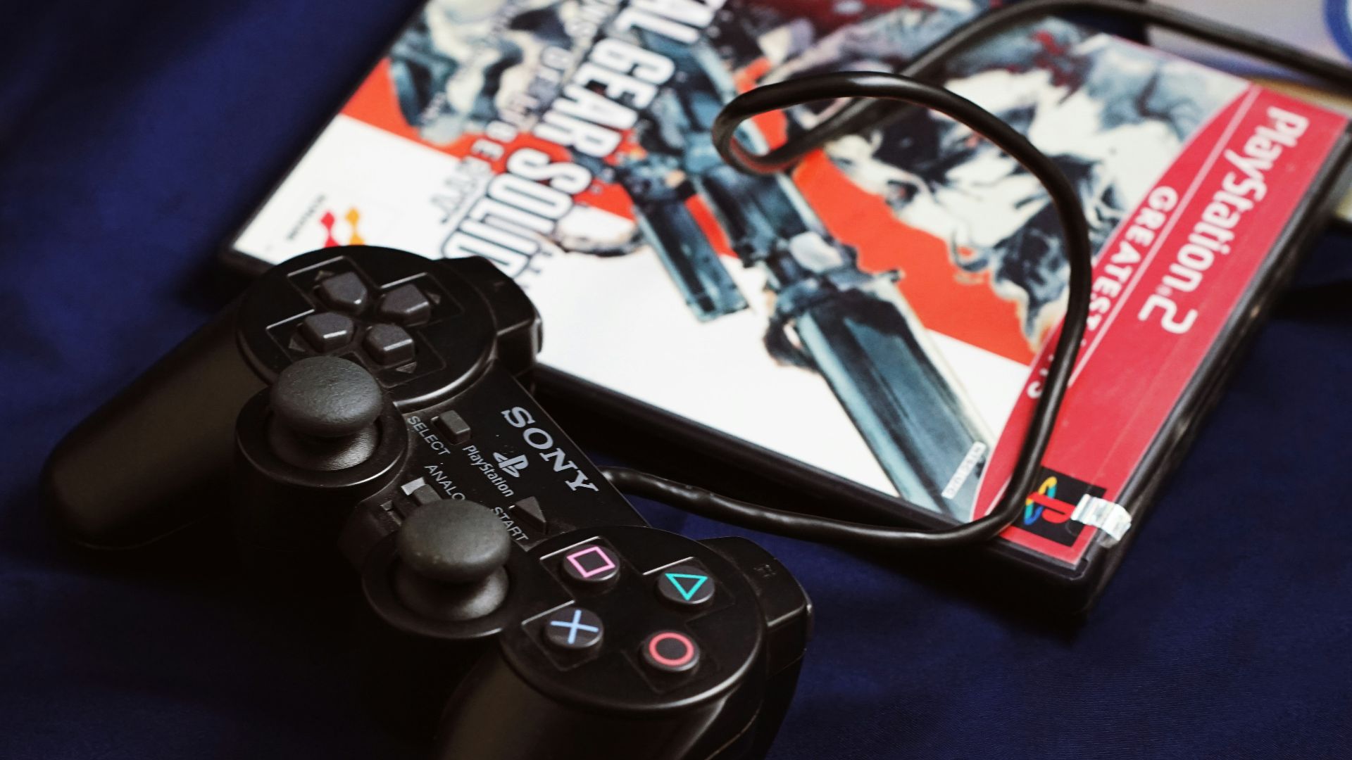 a couple of video game controllers sitting next to a dvd