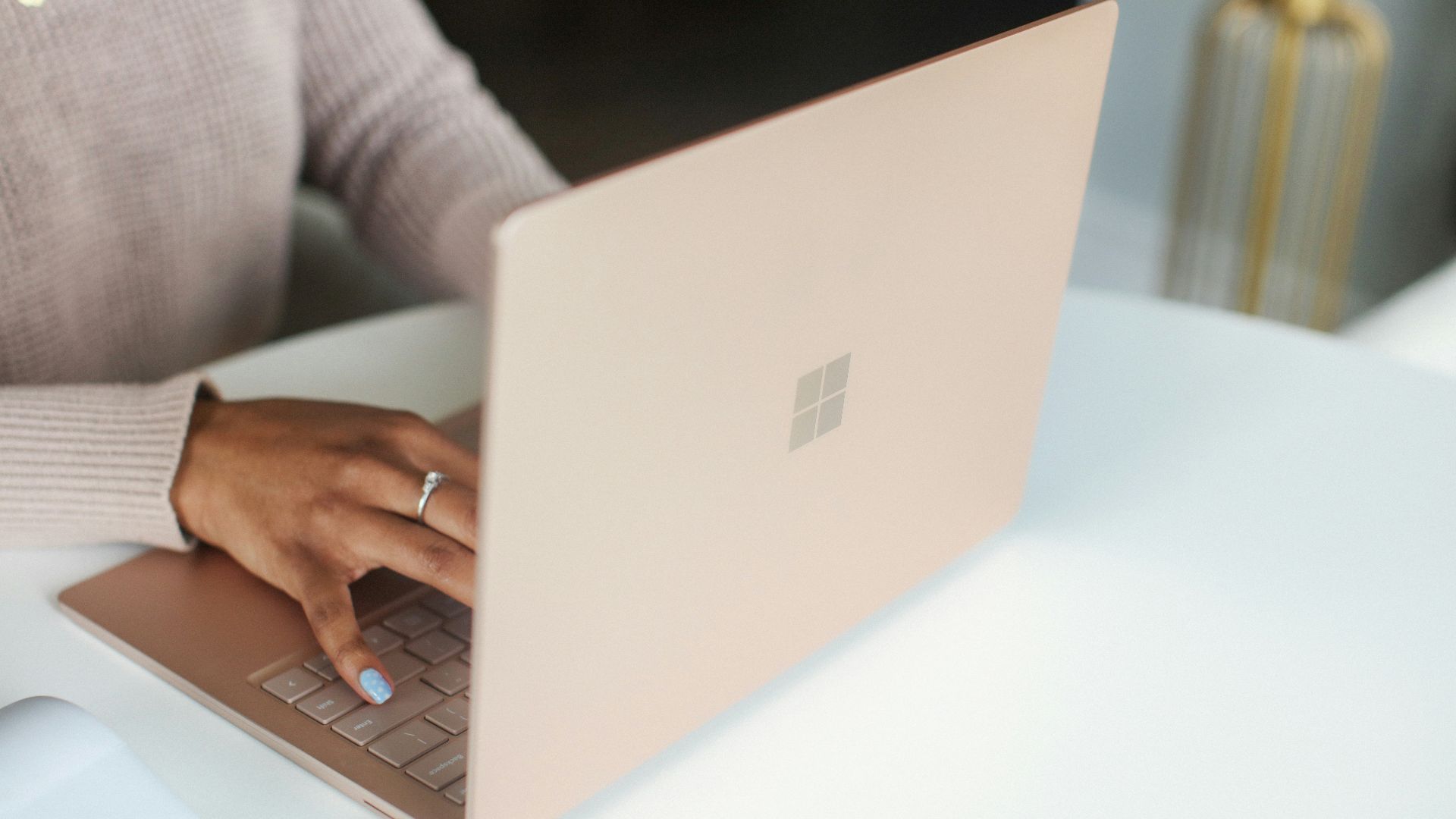 person in gray long sleeved shirt using Surface laptop