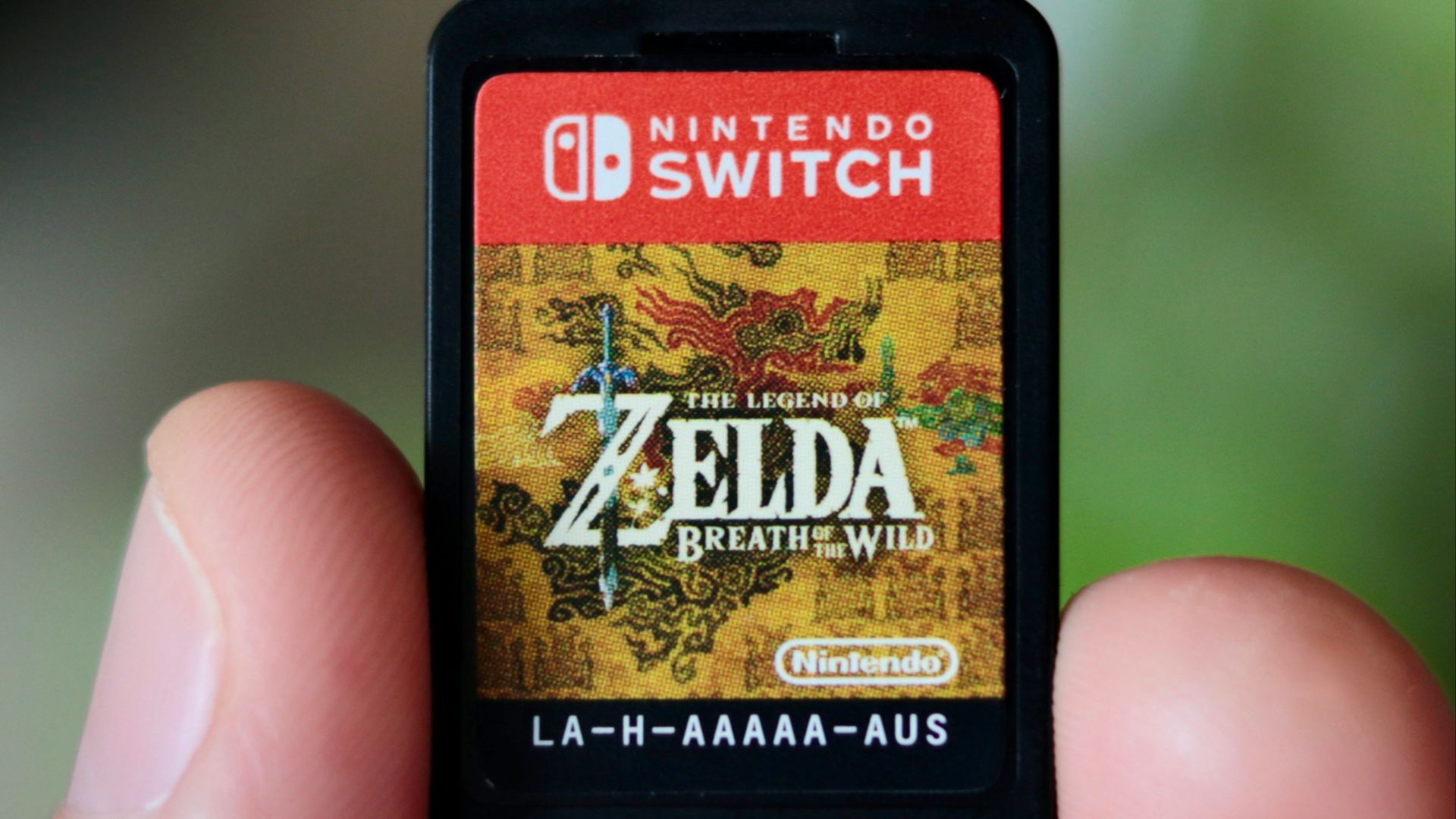 a hand holding a nintendo wii game card
