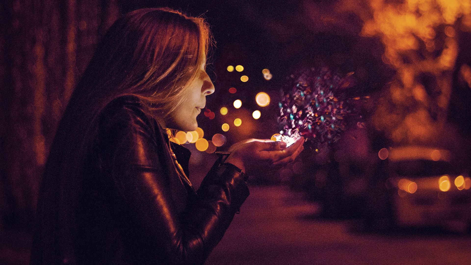 woman blowing sprinkle in her hand