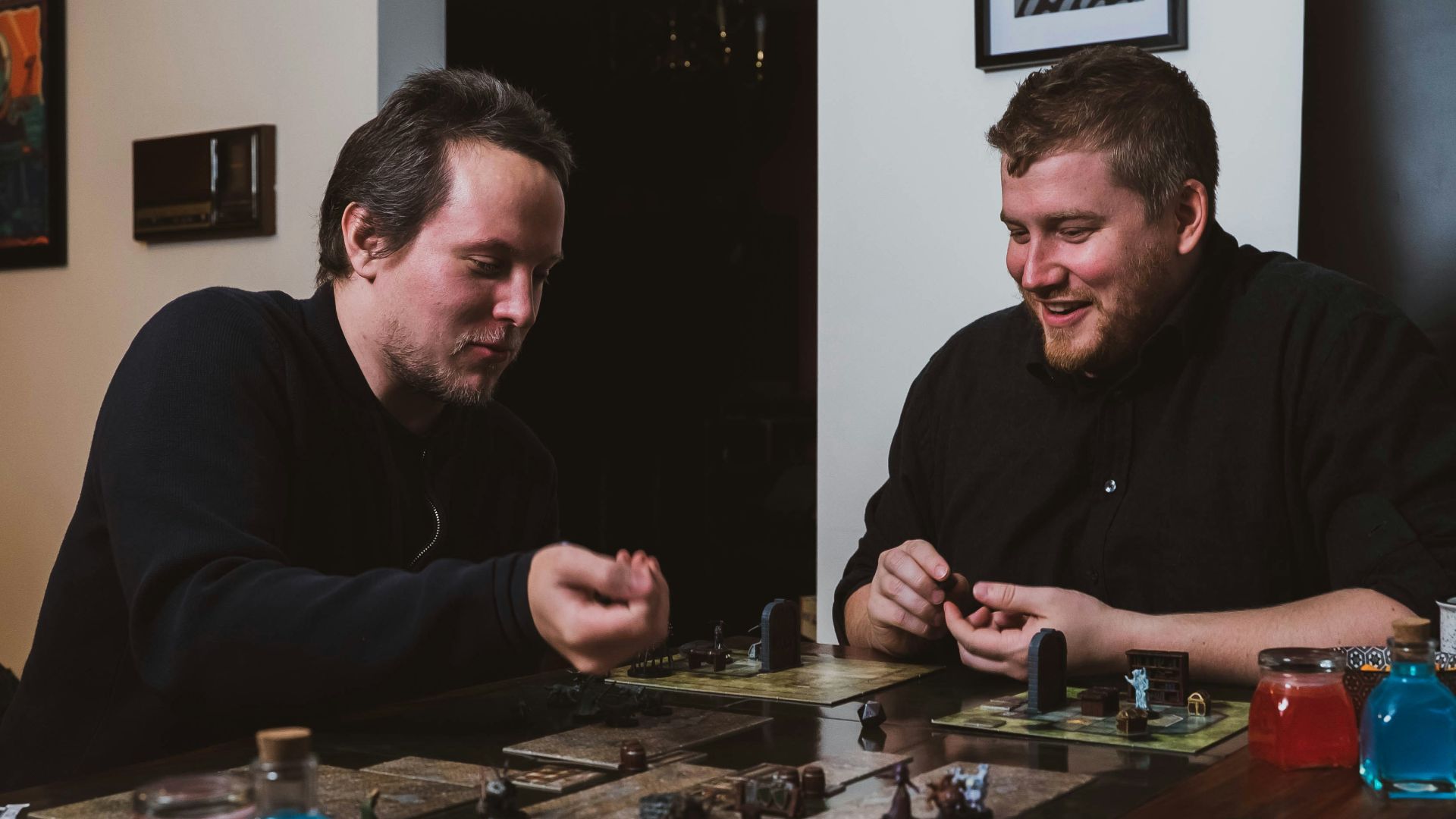 two men sitting at a table playing a board game