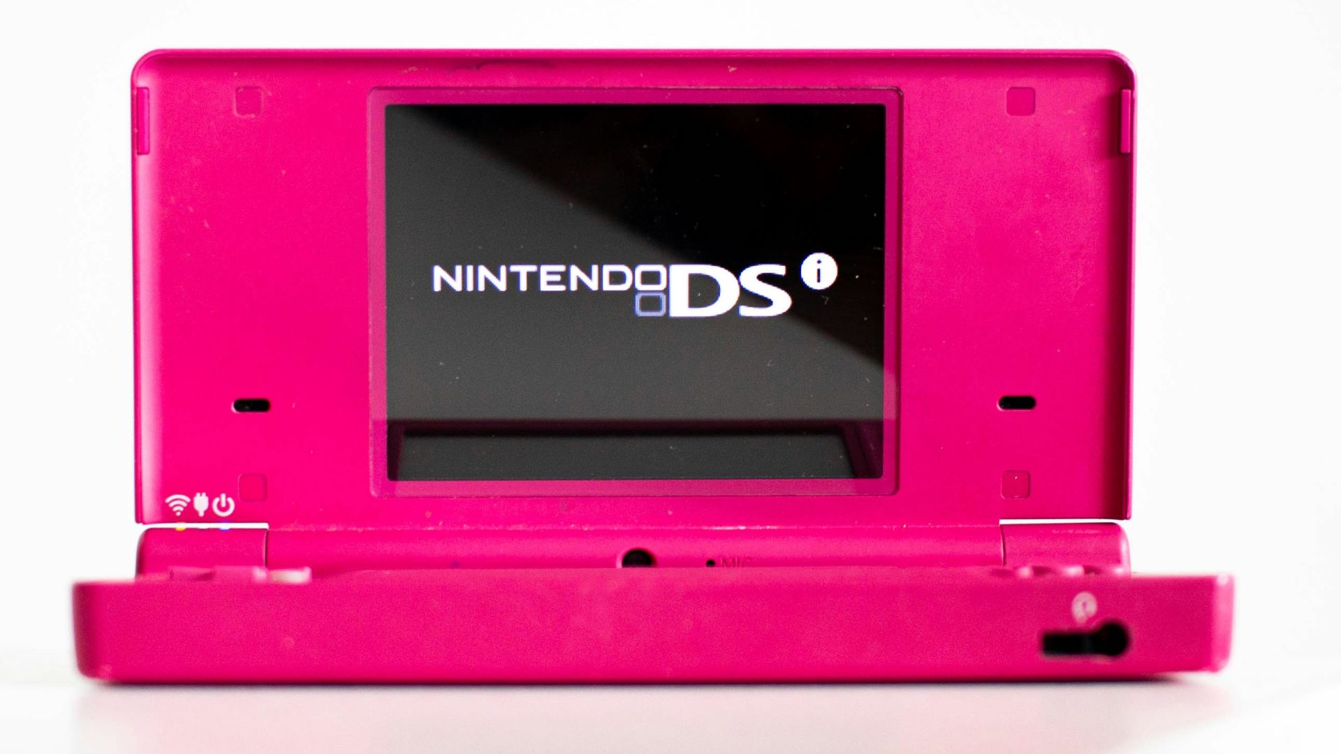 a pink nintendo ds sitting on top of a white table