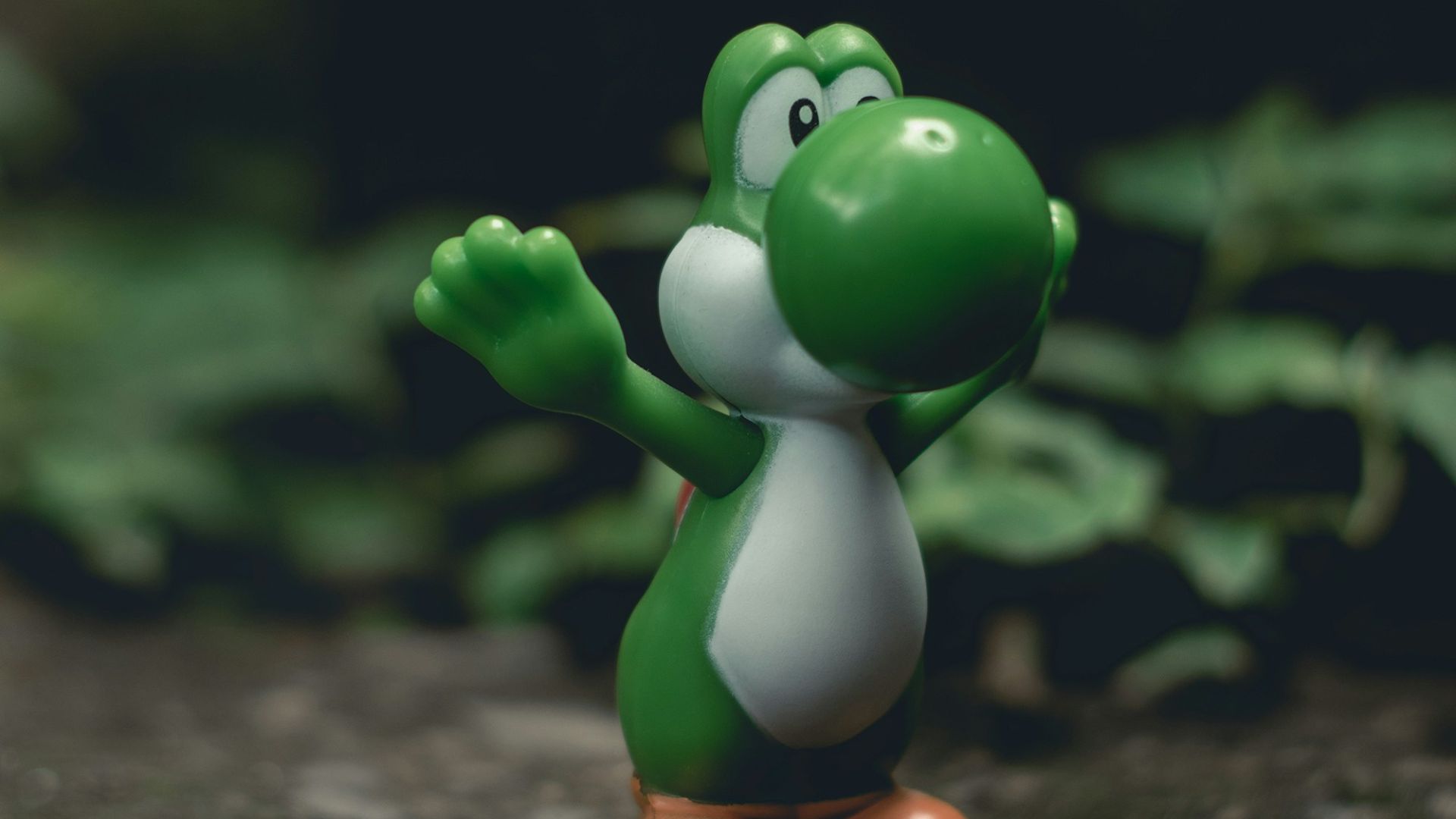 green frog figurine on black and brown surface