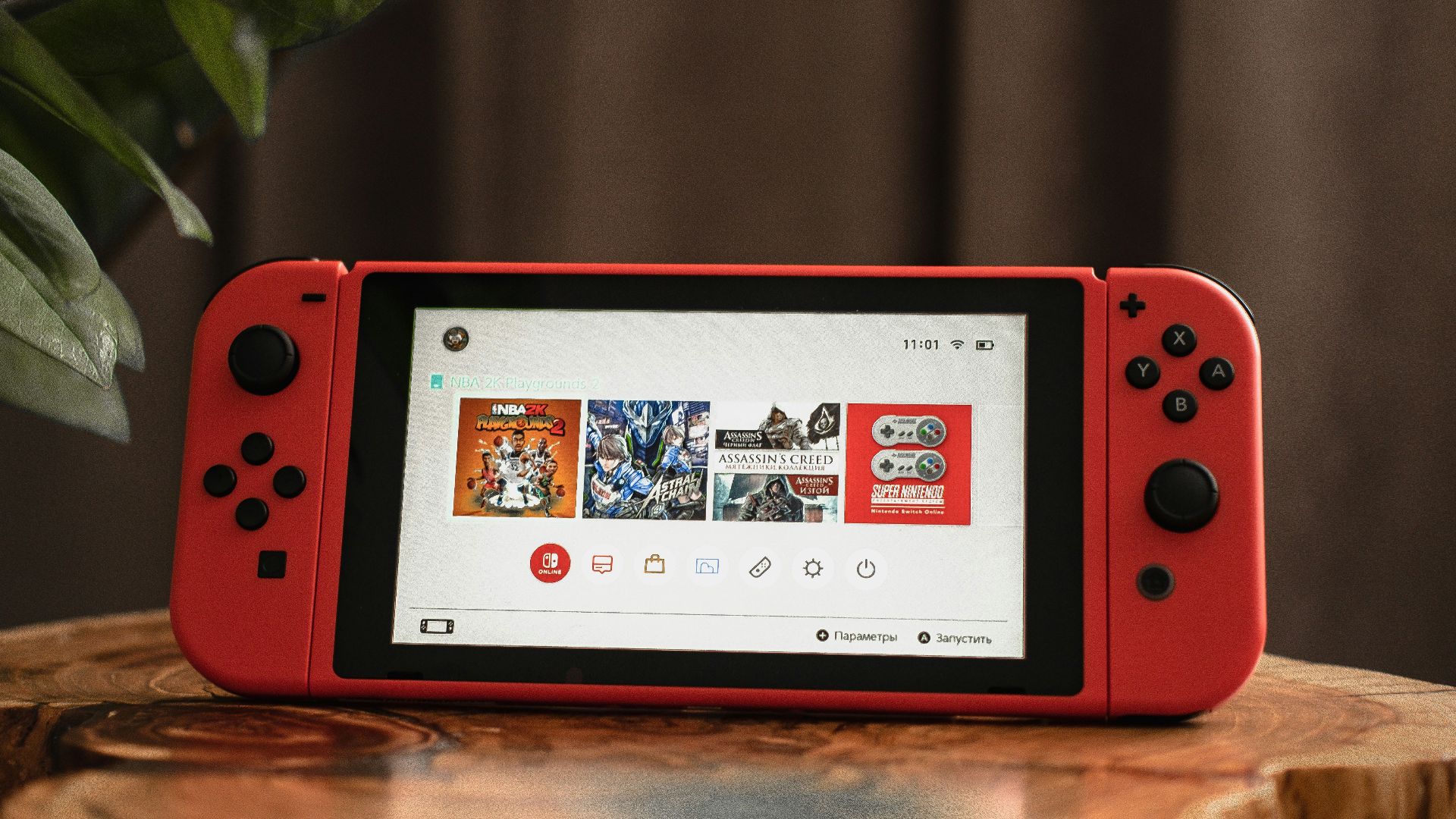 red nintendo switch on brown wooden table