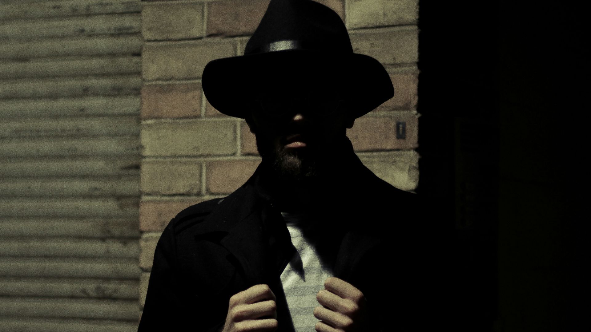 man wearing black fedora hat and black suit jacket