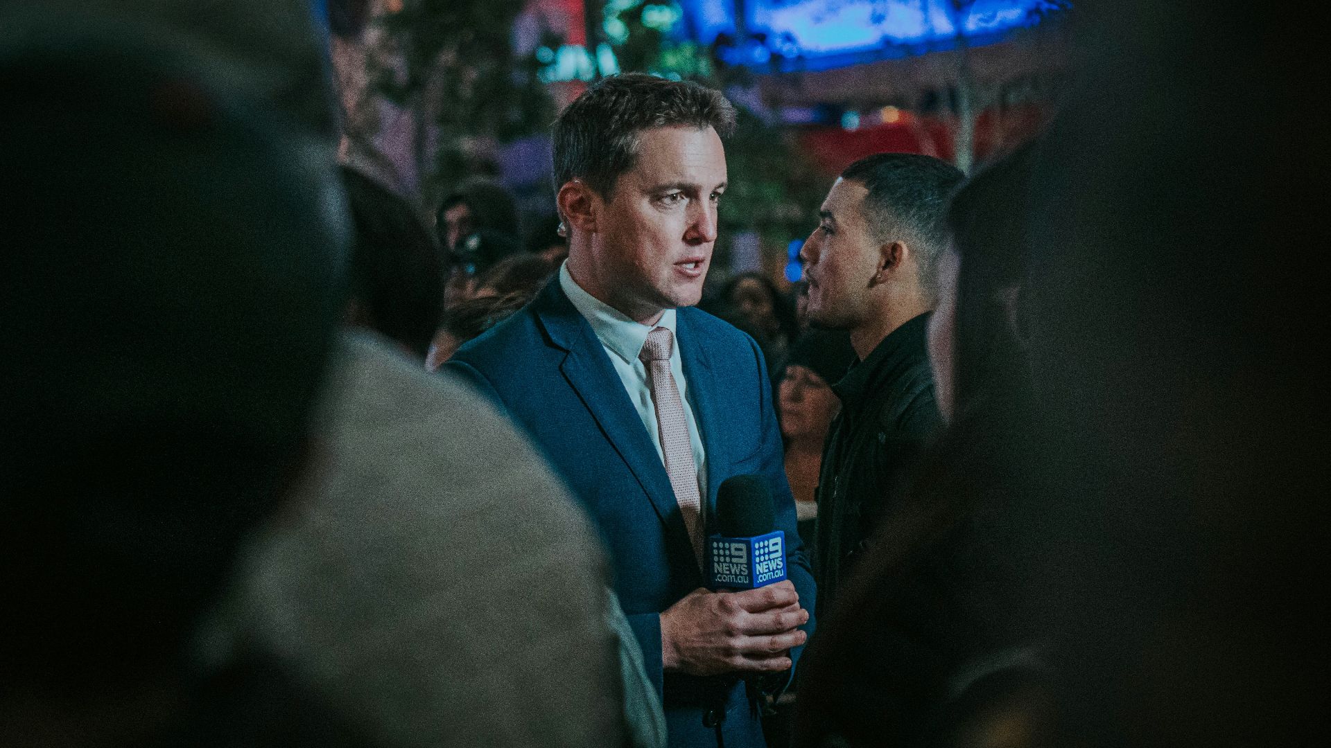 man in black suit standing in front of man in black suit