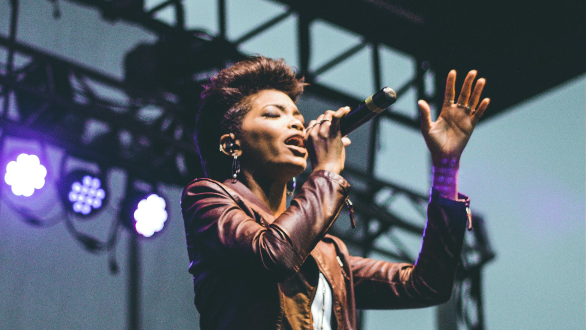 selective focus photography of woman raising left hand