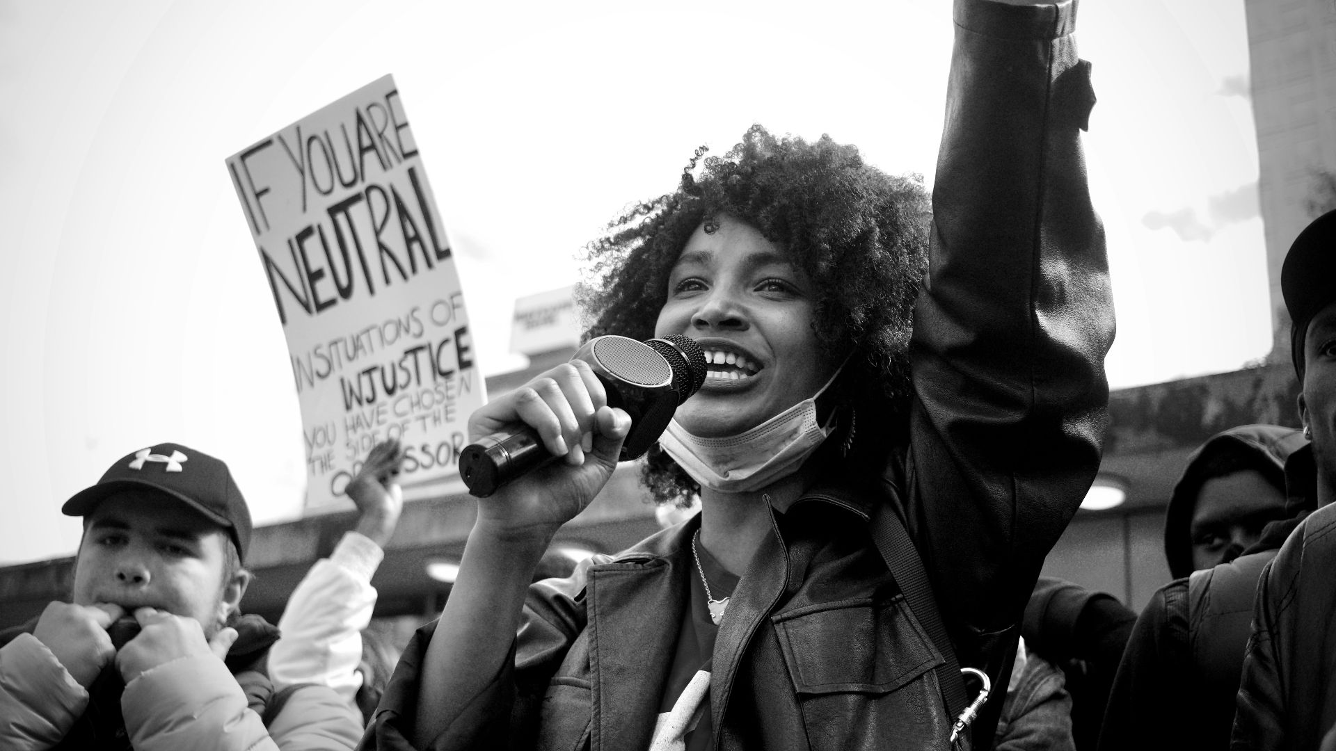 grayscale photo of man in black jacket holding black smartphone