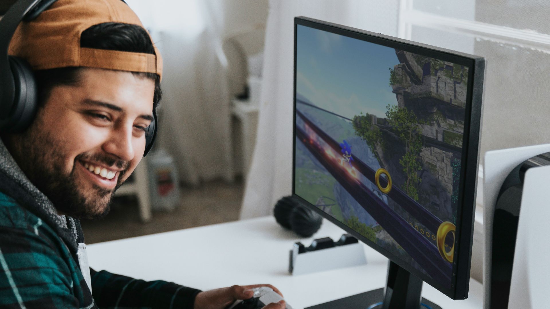 a man wearing headphones and sitting at a desk with a computer