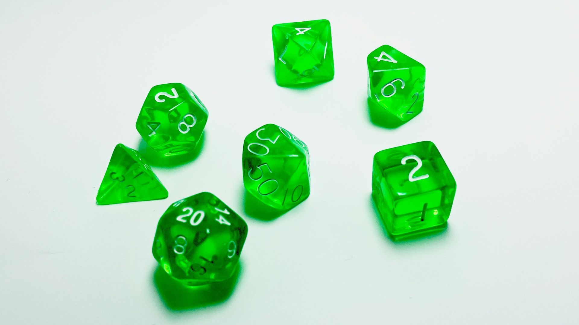 green plastic dice on white surface