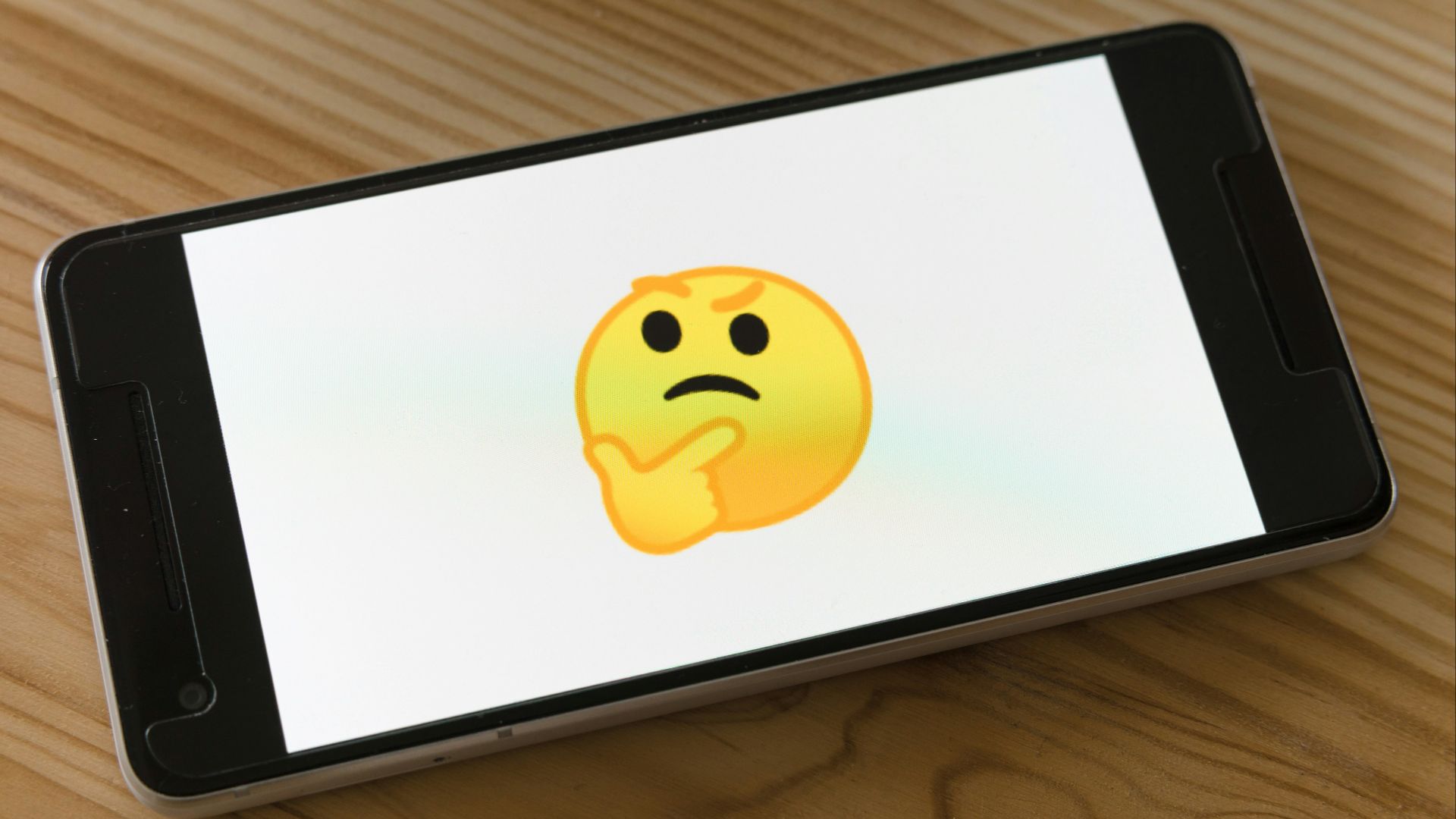 black flat screen tv turned on displaying yellow emoji