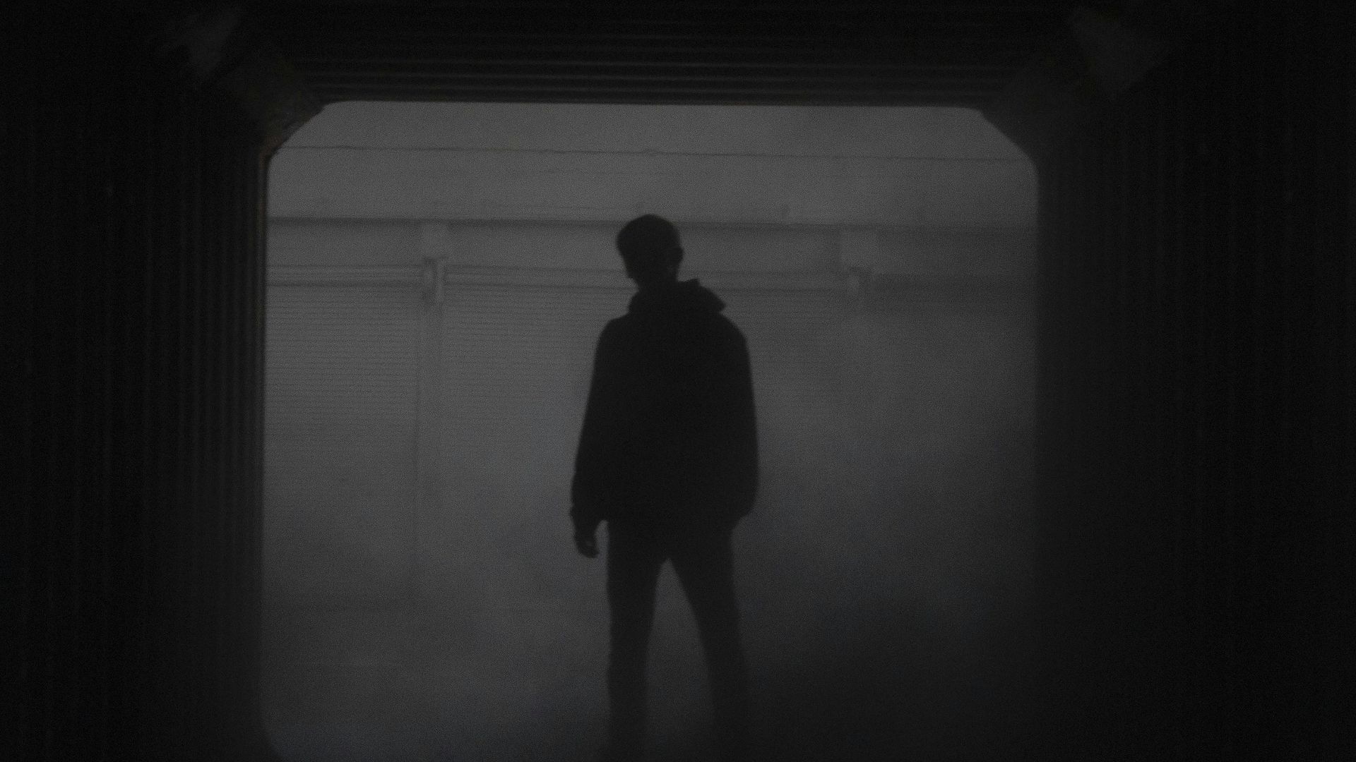 silhouette of man standing in front of window