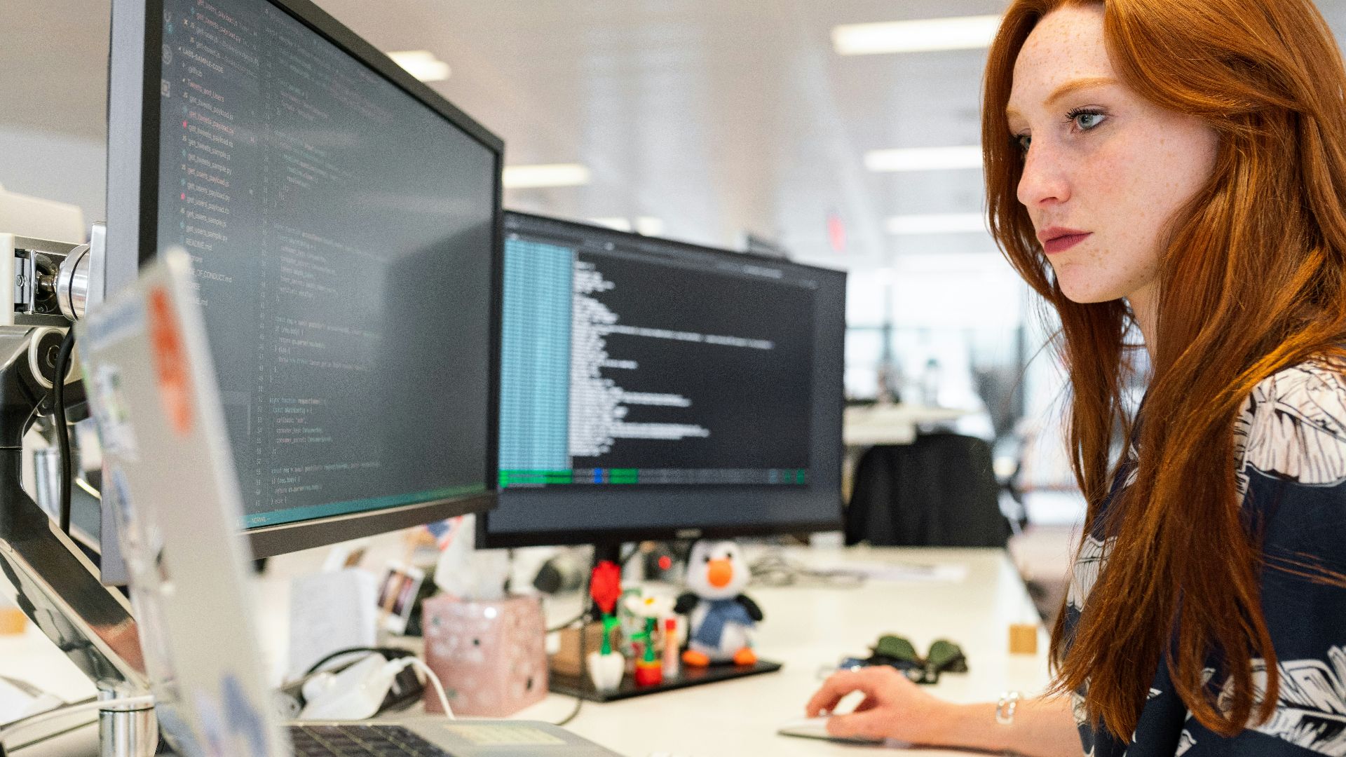 woman in green shirt sitting in front of computer
