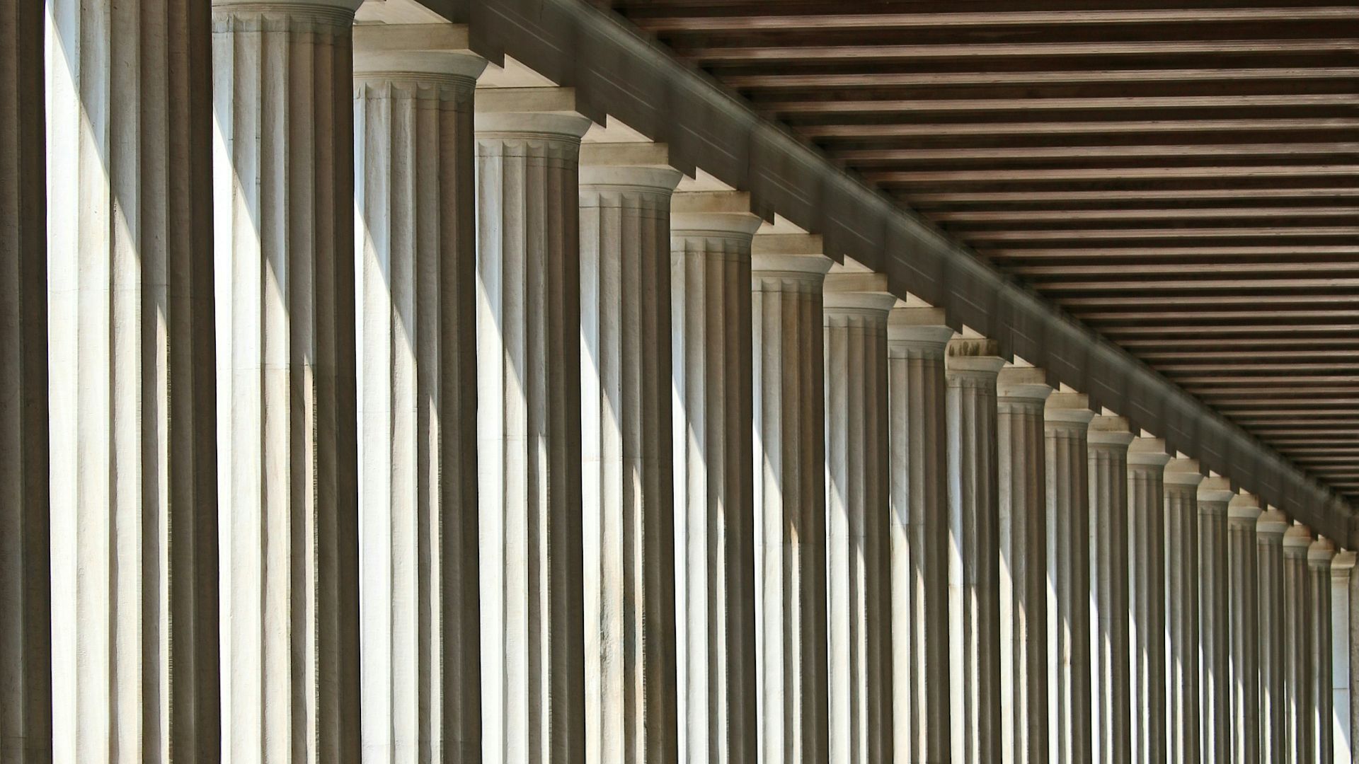 inline white concrete pillars with empty hallway