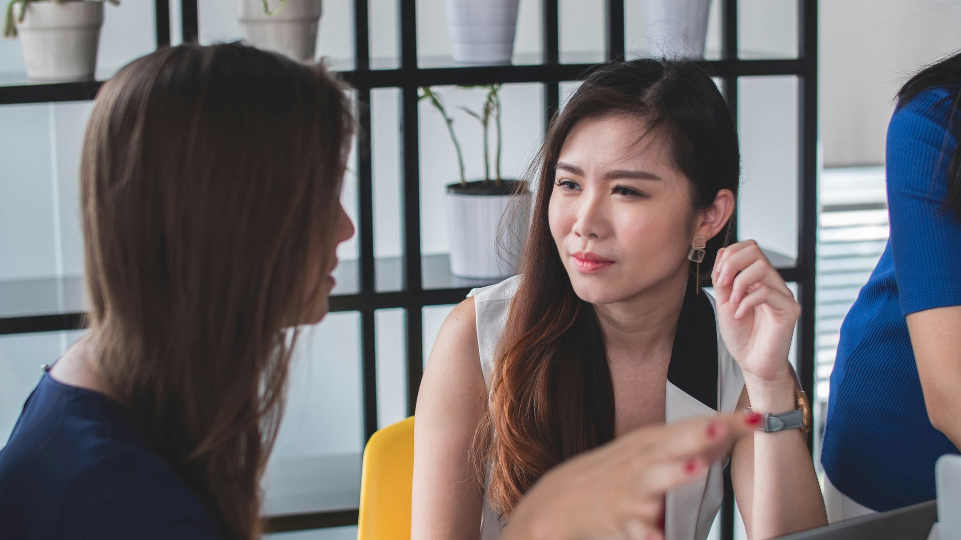 woman sitting on yellow armless chair near gray laptop computer