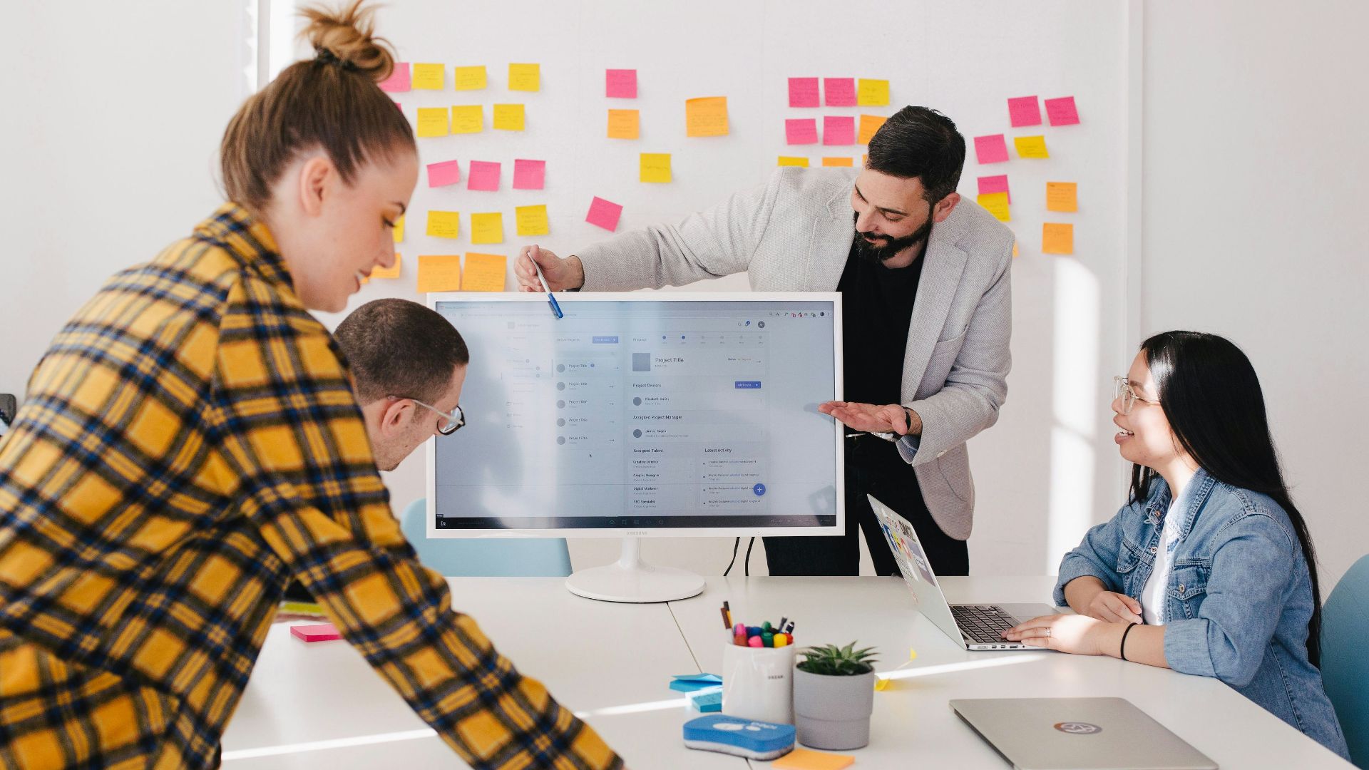 man standing behind flat screen computer monitor