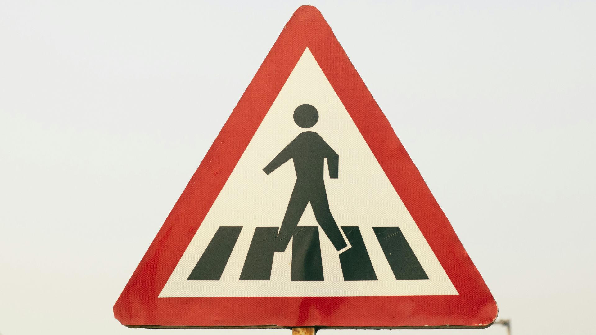 a pedestrian crossing sign on a city street