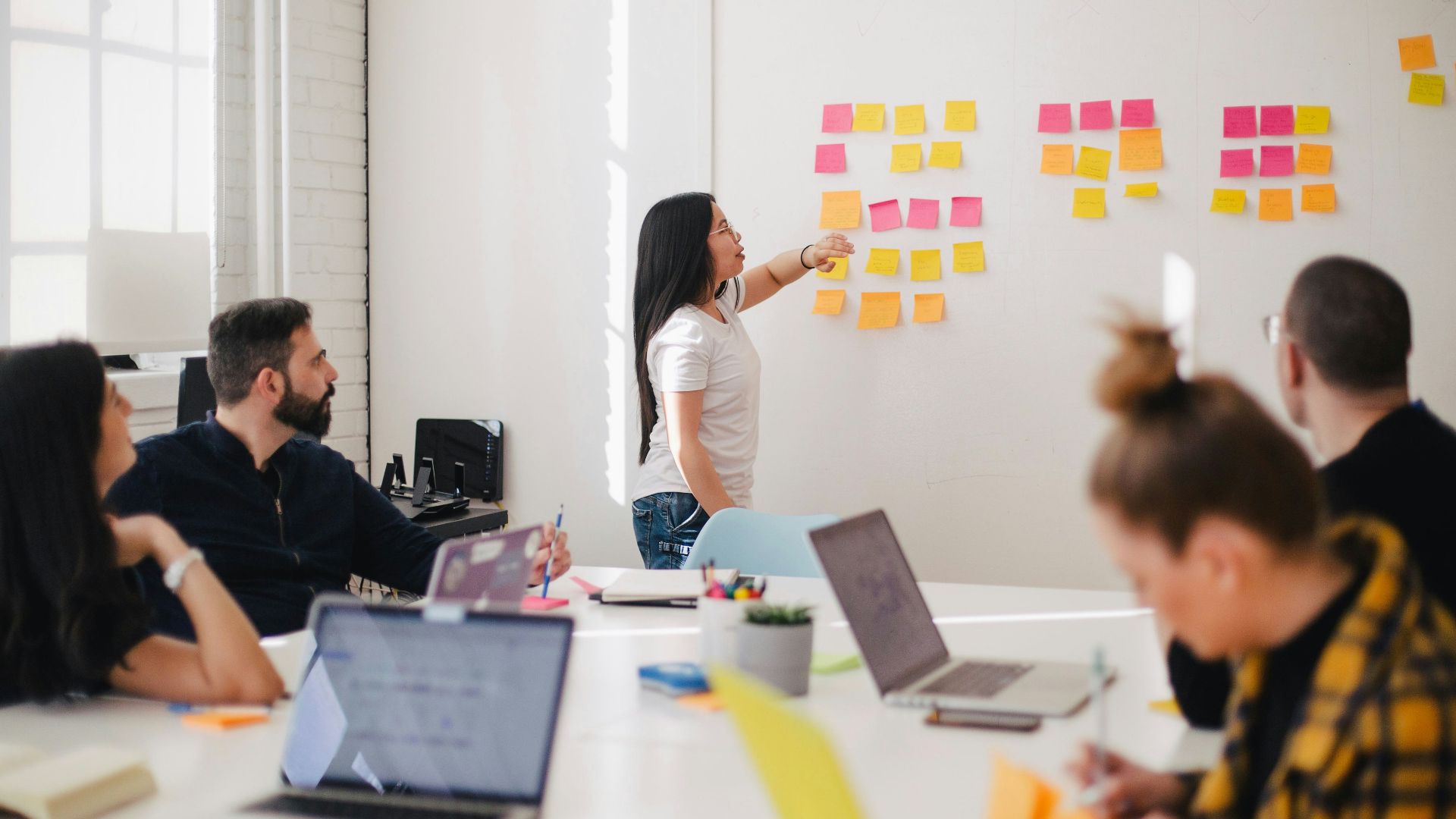 woman placing sticky notes on wall