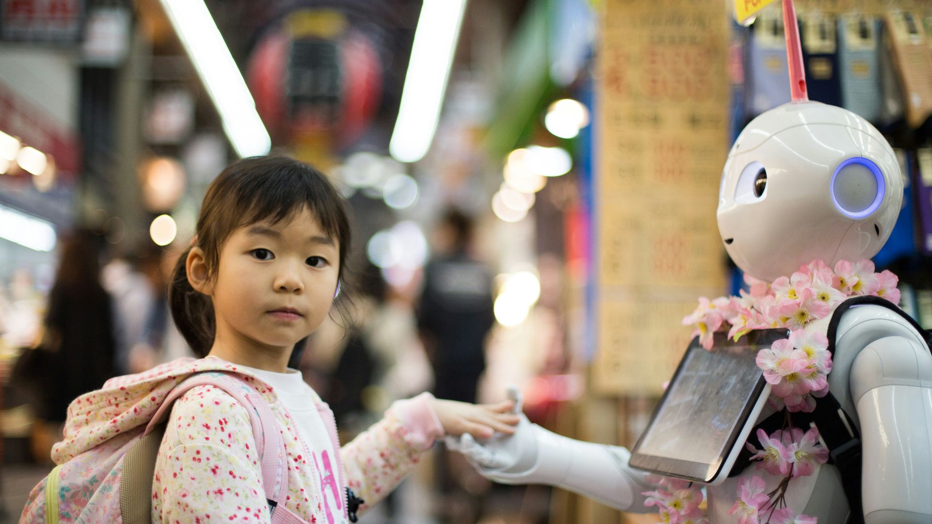 photo of girl laying left hand on white digital robot
