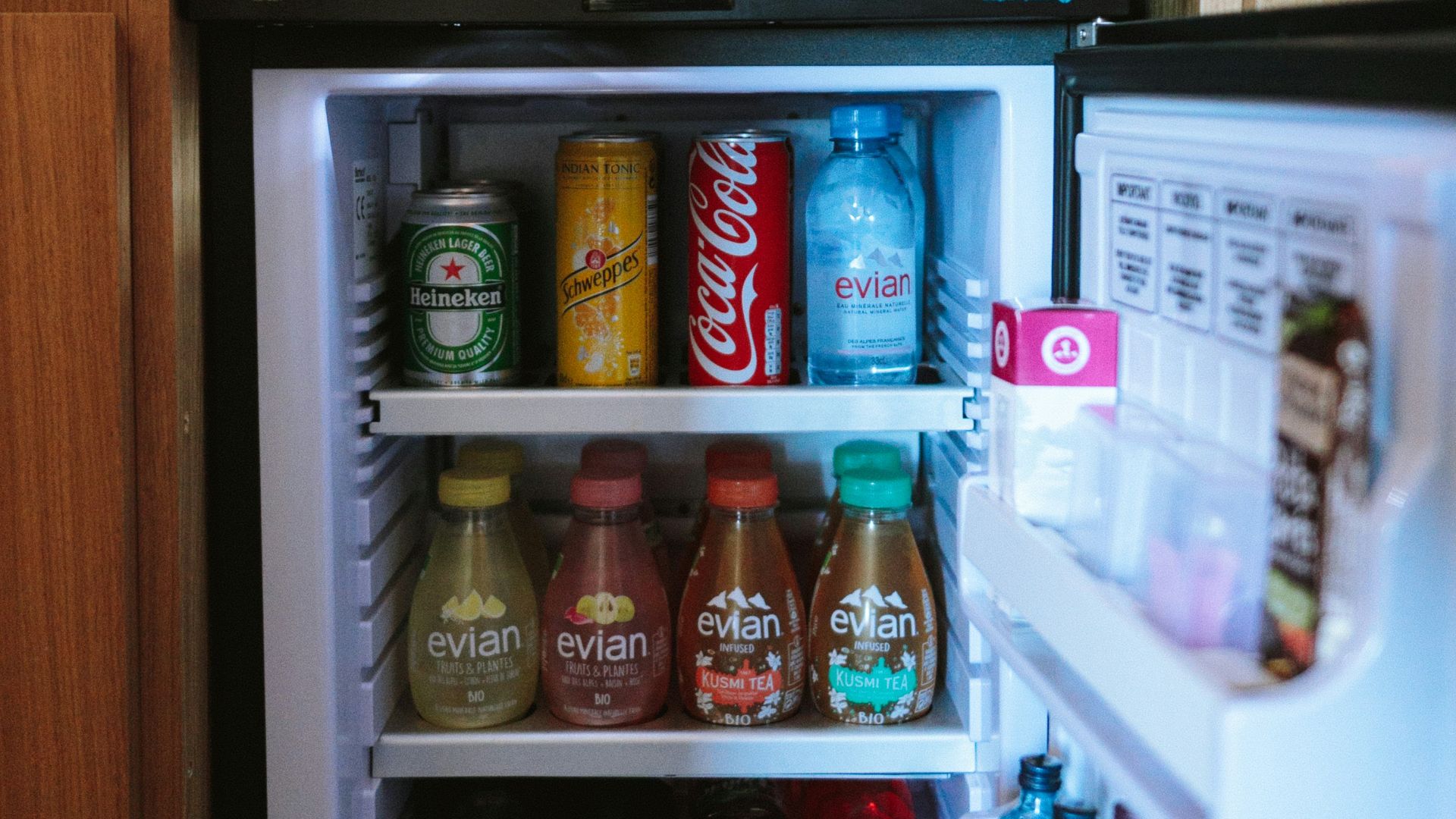open black compact refrigerator filled with soda bottles