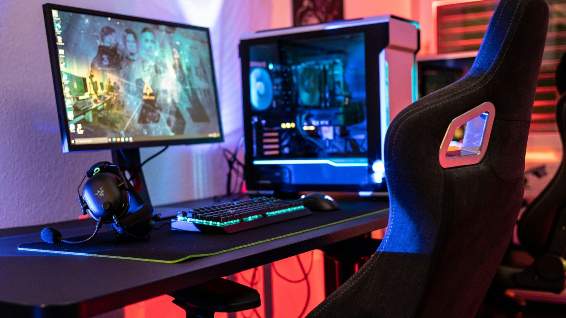 a desk with a computer and a gaming chair