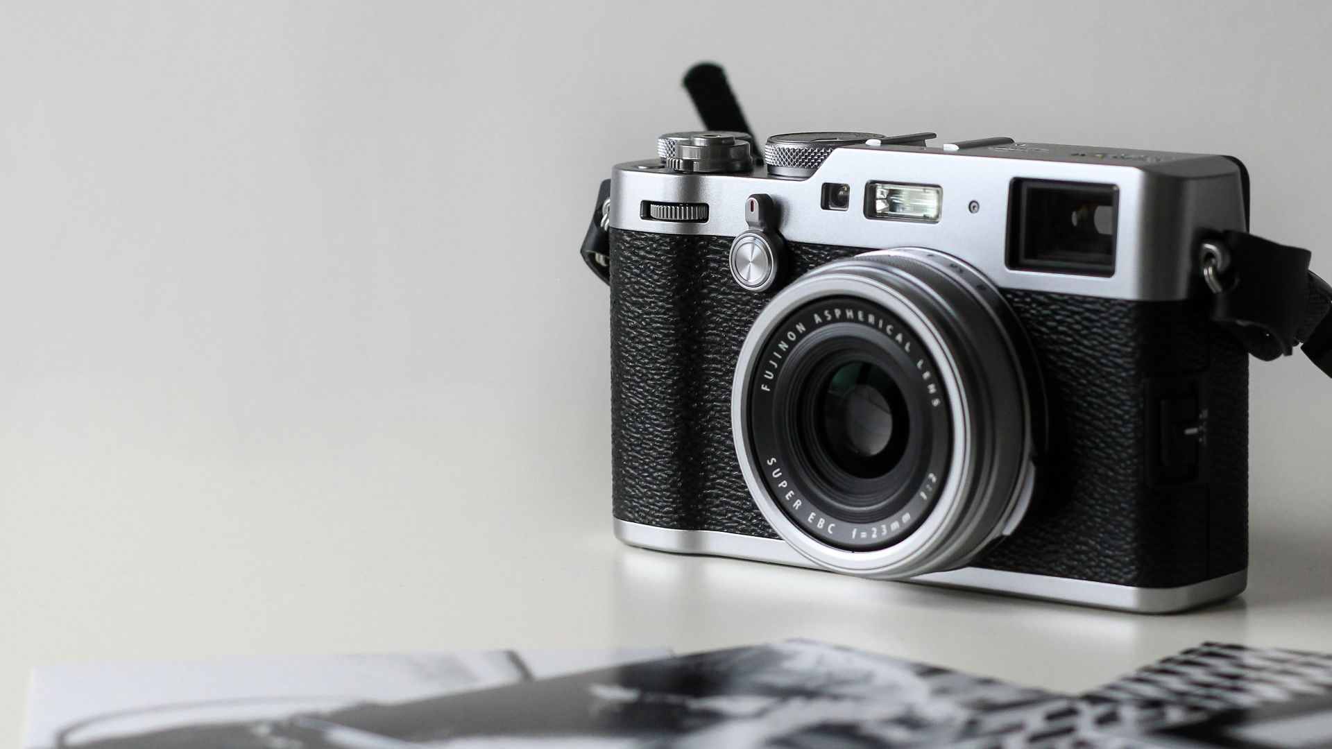 black and gray film camera near printed photos