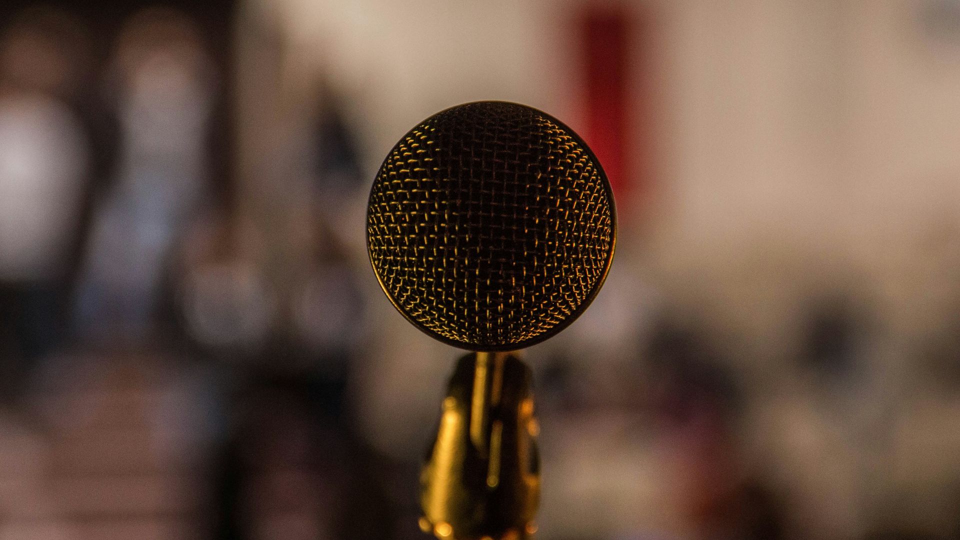 selective focus photography of brass-colored microphone